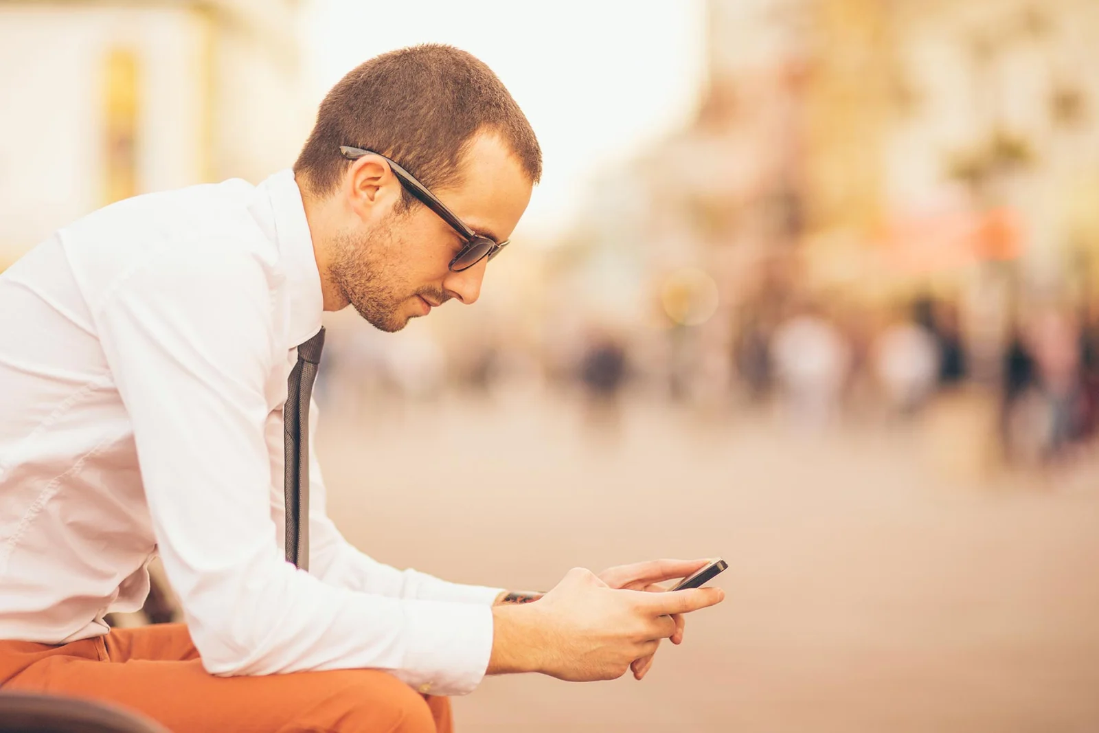 man sitting looking at phone