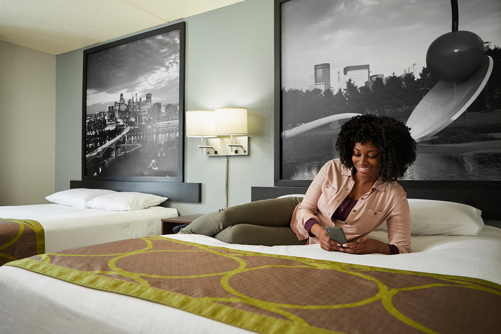 Woman relaxing on the bed in the Super 8 guest room