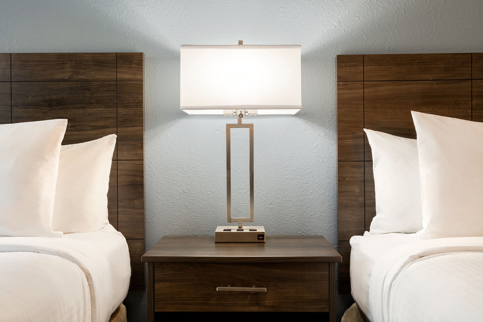 double beds with a lit lamp in the middle