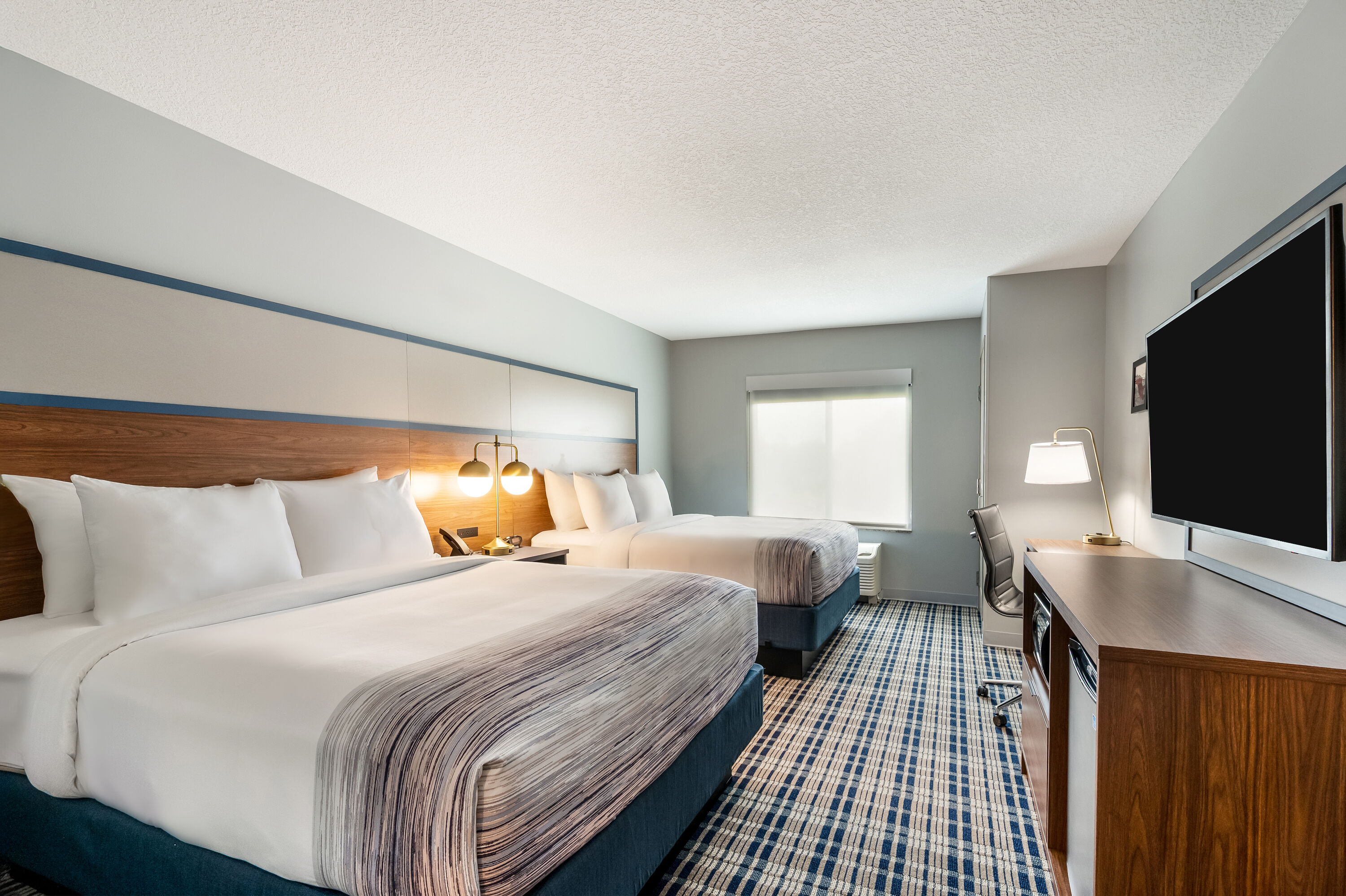 Queen bed guest room at the AmericInn by Wyndham Fairfield in Fairfield, Iowa