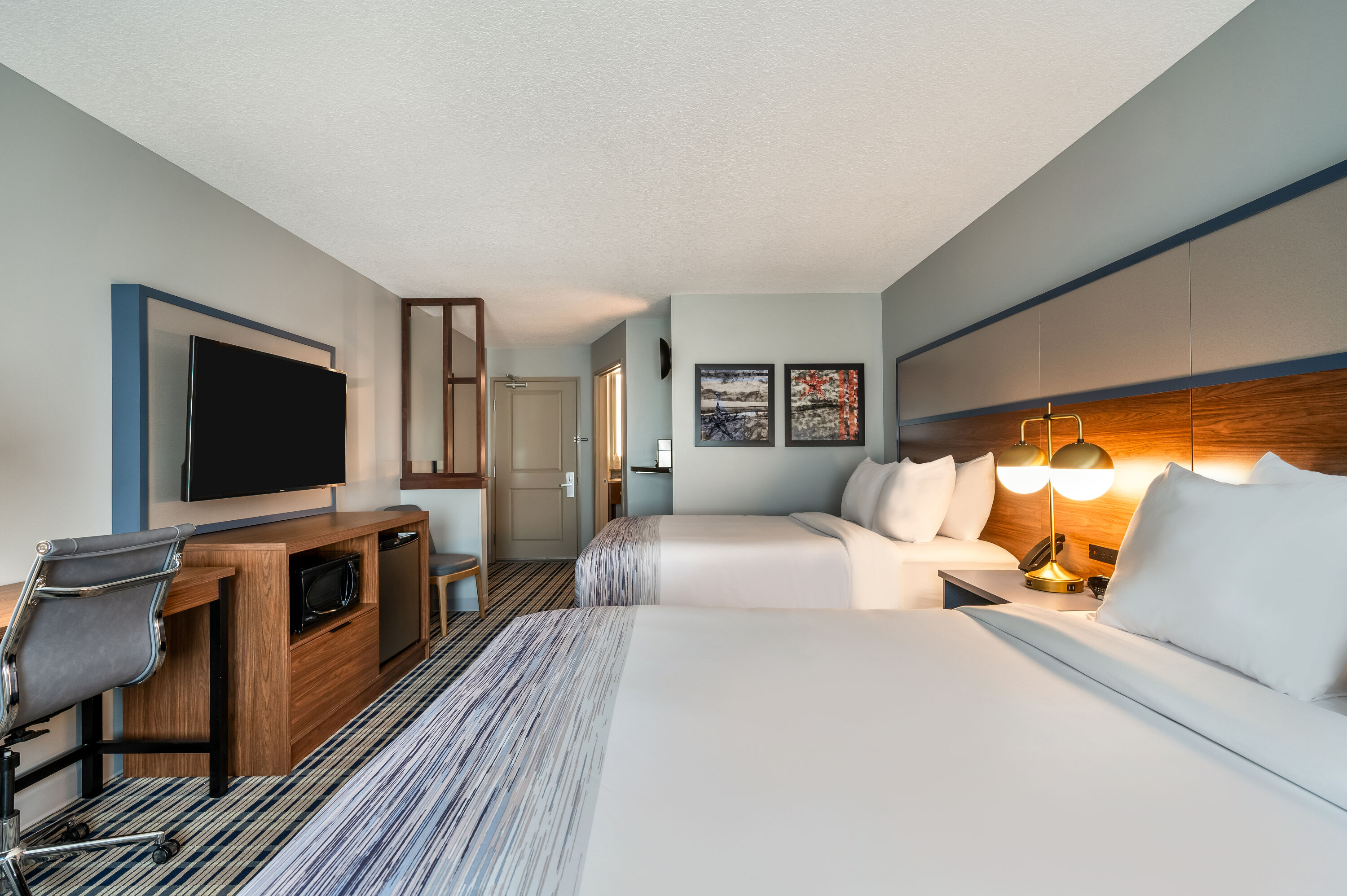 Queen bed guest room at the AmericInn by Wyndham Fairfield in Fairfield, Iowa