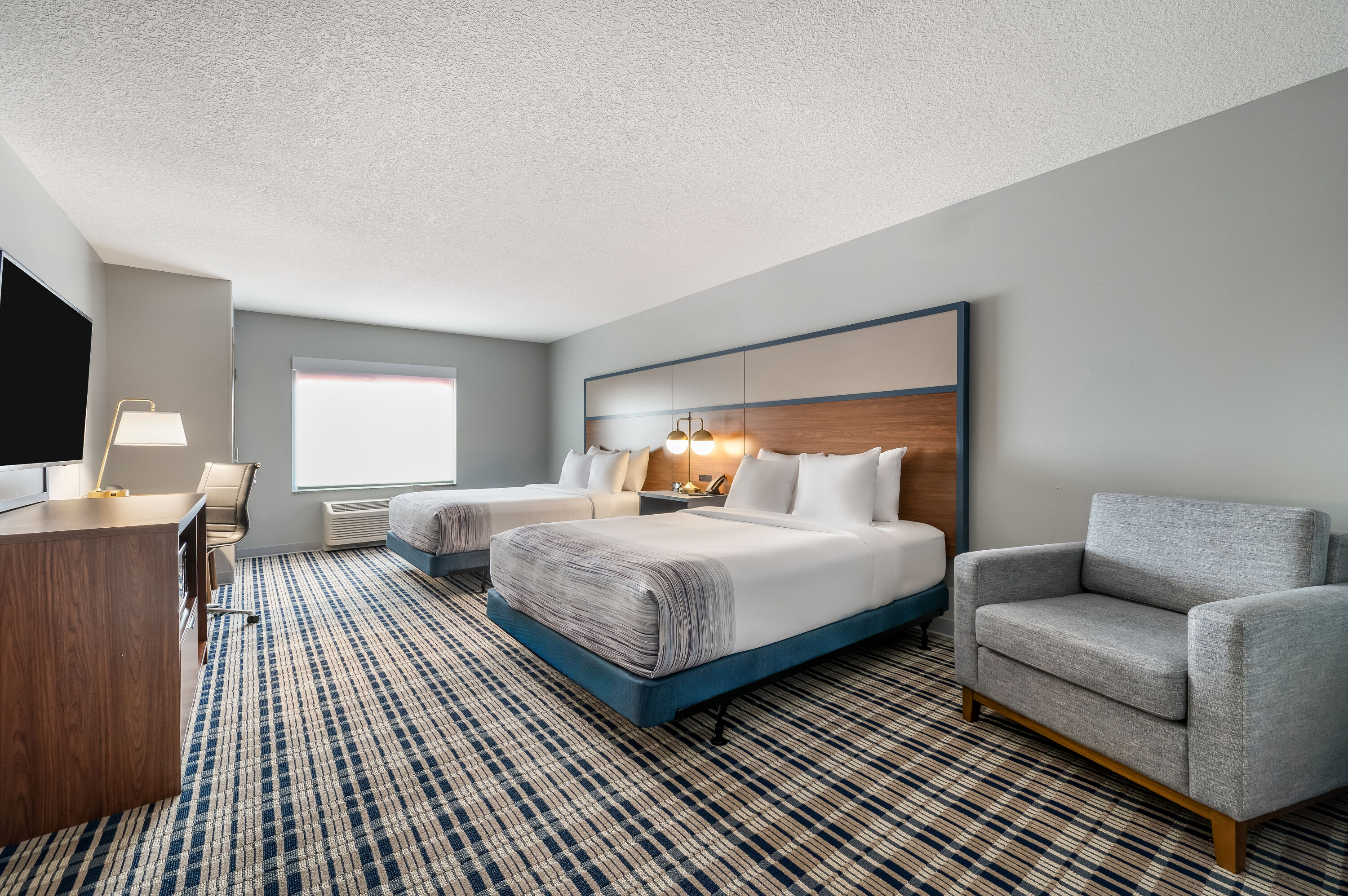 Queen bed guest room at the AmericInn by Wyndham Fairfield in Fairfield, Iowa