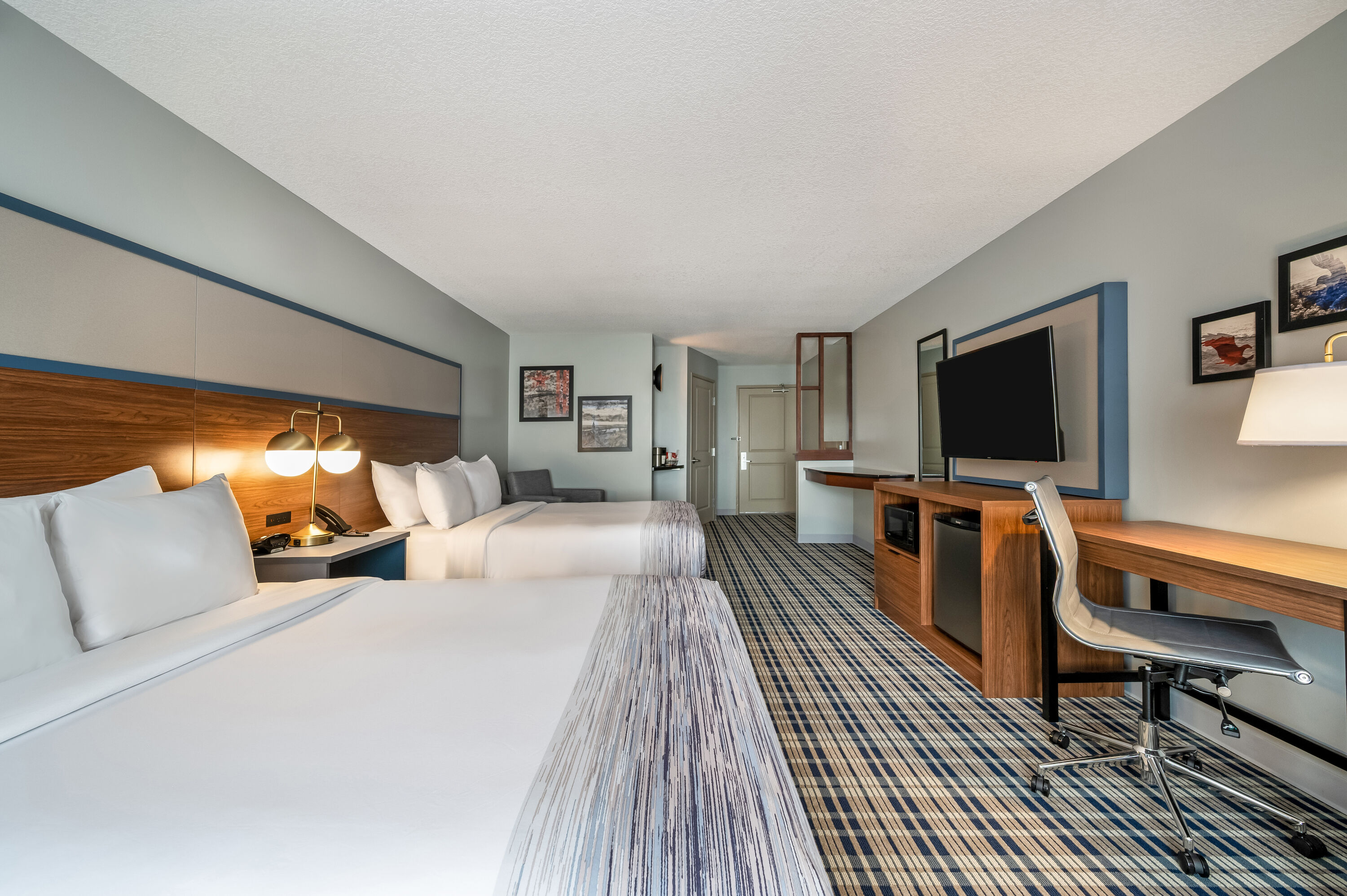 Queen bed guest room at the AmericInn by Wyndham Fairfield in Fairfield, Iowa