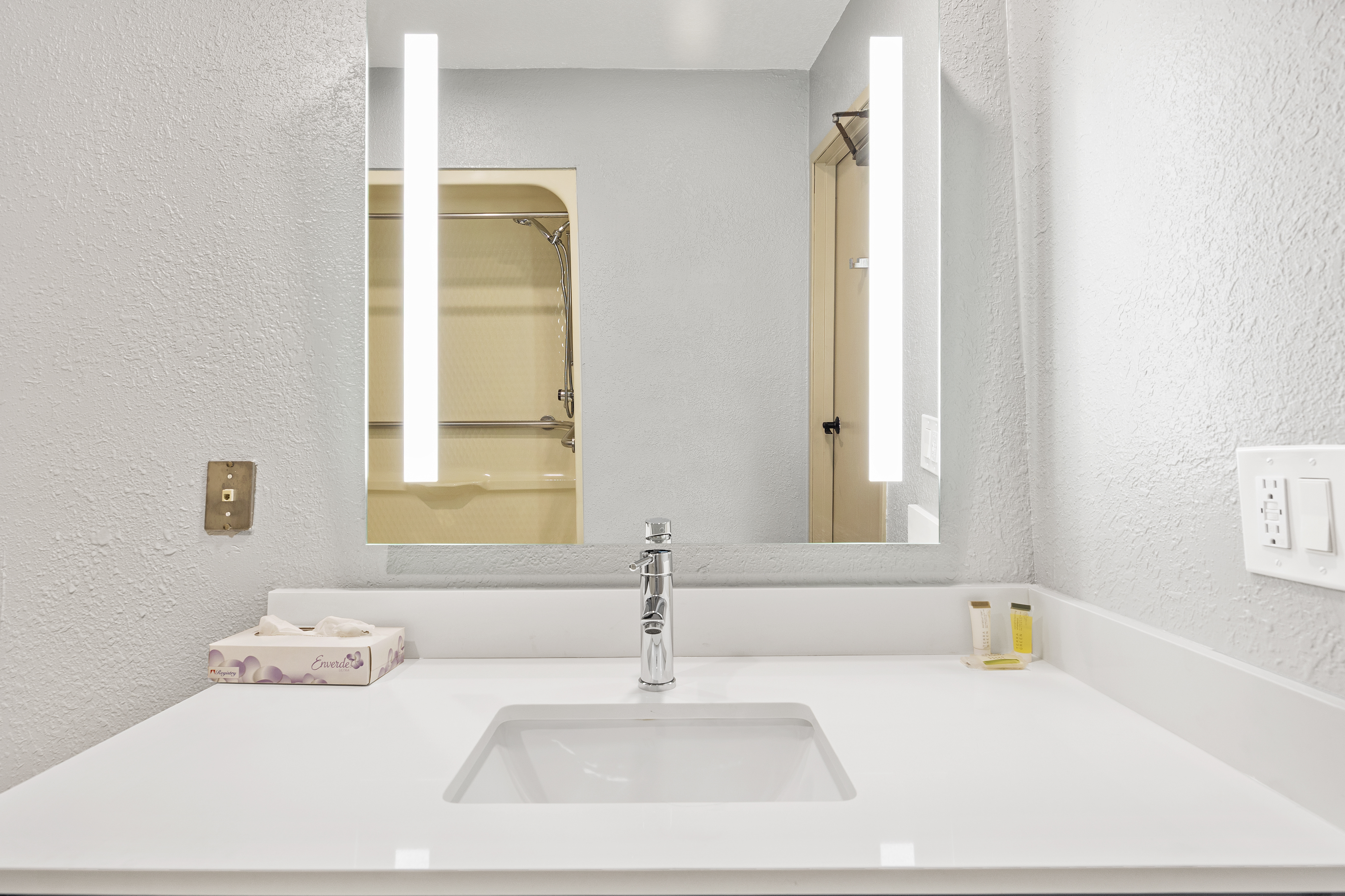 Guest room bath at the AmericInn by Wyndham Urbana/Champaign University Area in Urbana, Illinois