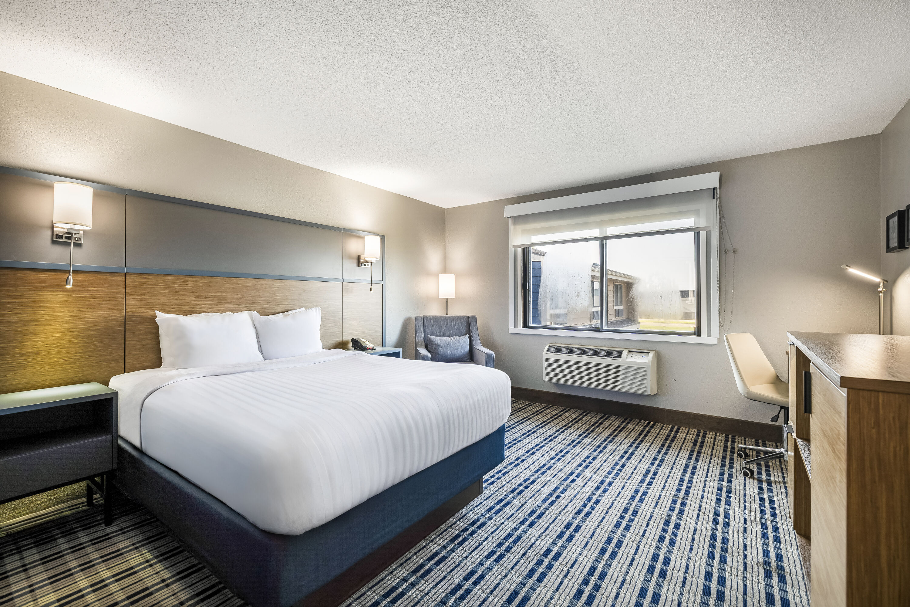 Queen bed guest room at the AmericInn by Wyndham Albert Lea in Albert Lea, Minnesota