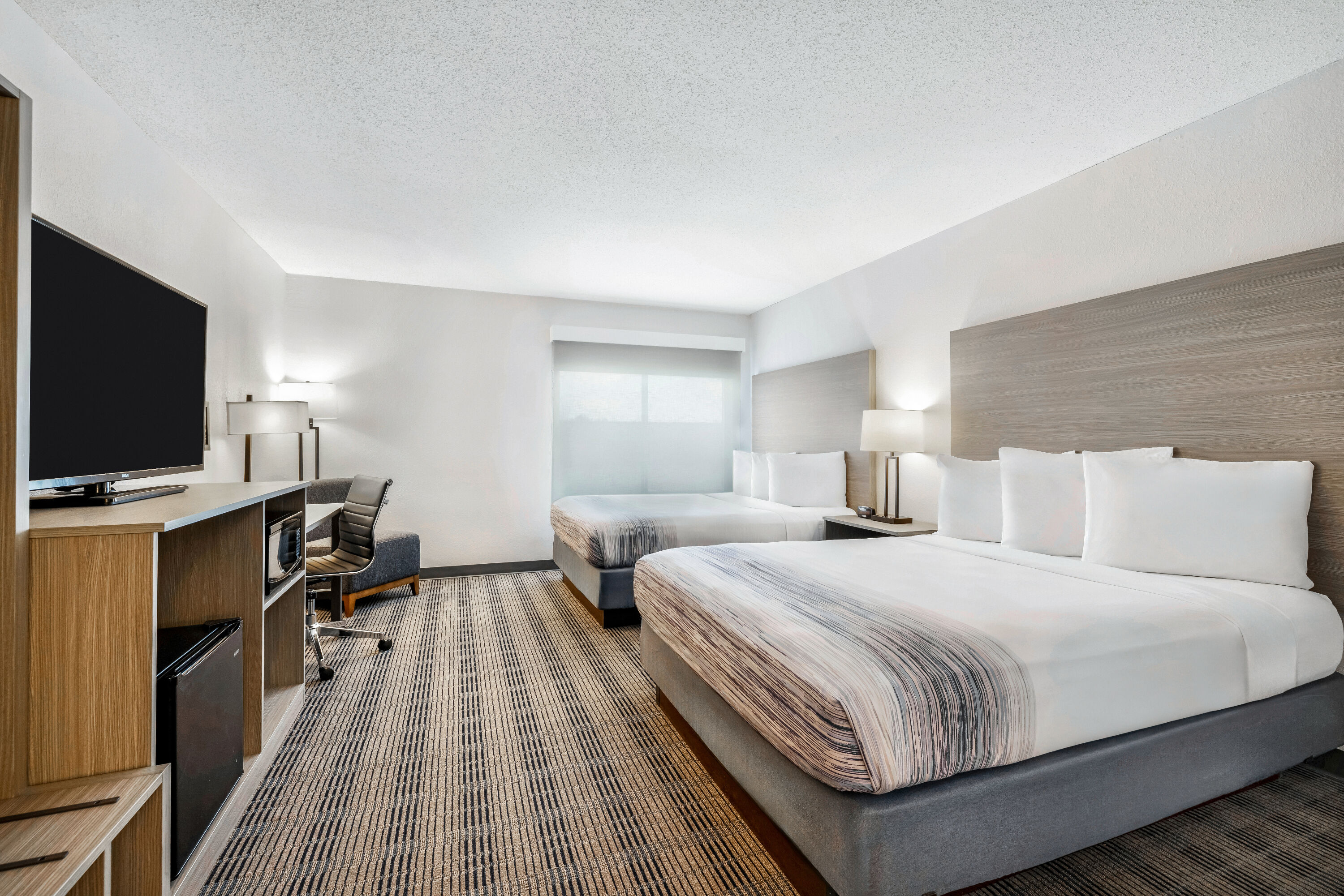 Queen bed guest room at the AmericInn by Wyndham Baxter Brainerd in Baxter, Minnesota