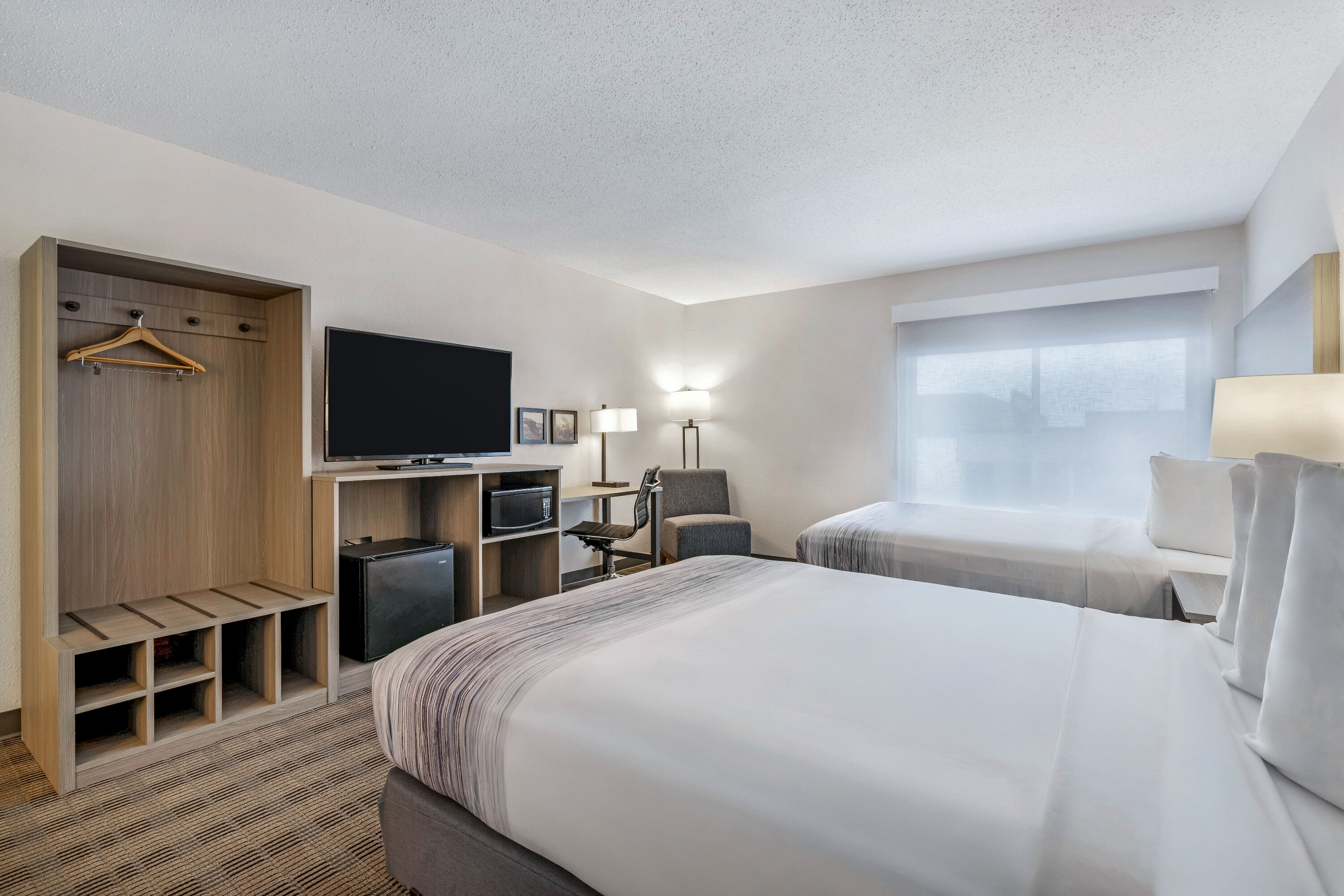 Queen bed guest room at the AmericInn by Wyndham Baxter Brainerd in Baxter, Minnesota