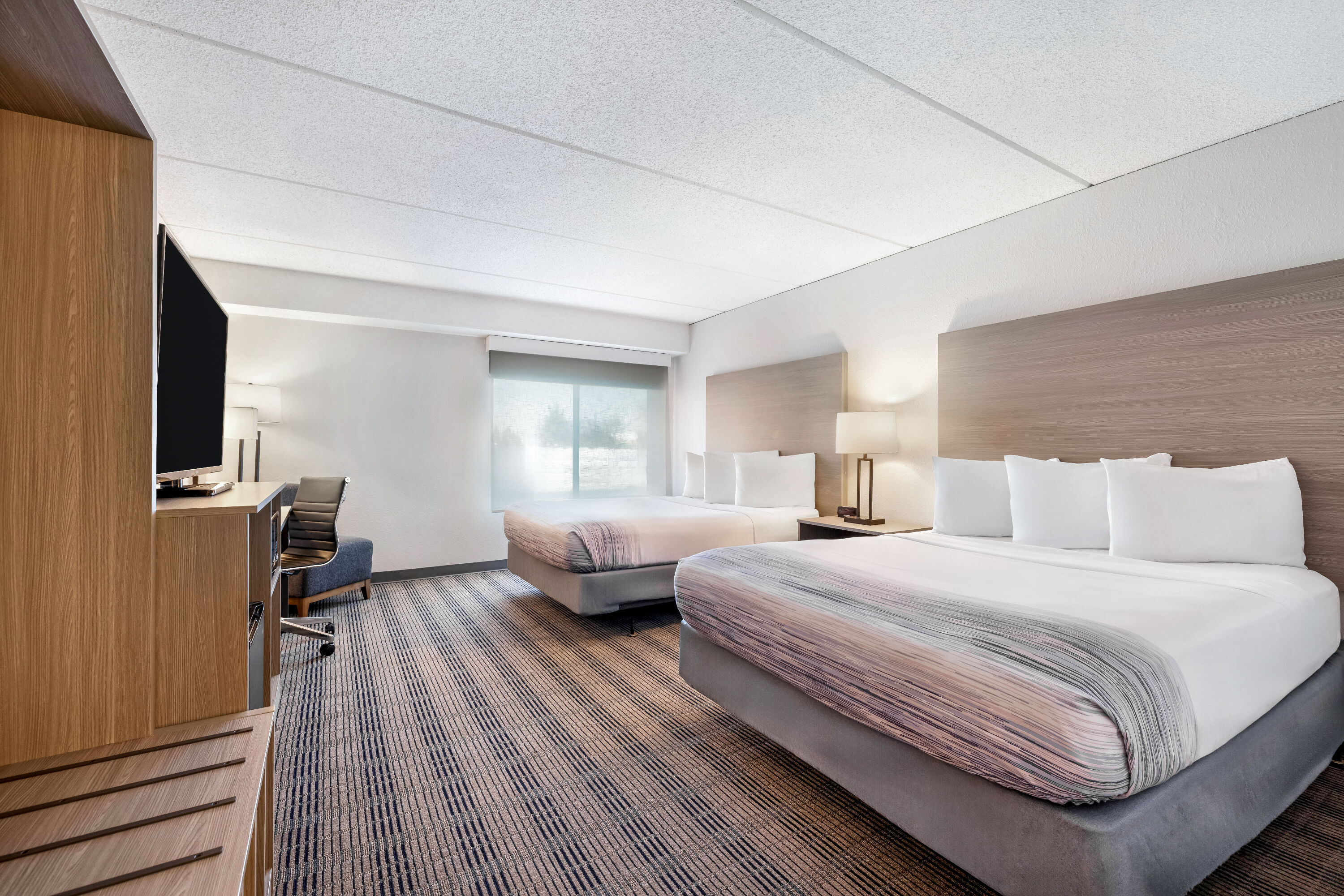 Queen bed guest room at the AmericInn by Wyndham Baxter Brainerd in Baxter, Minnesota