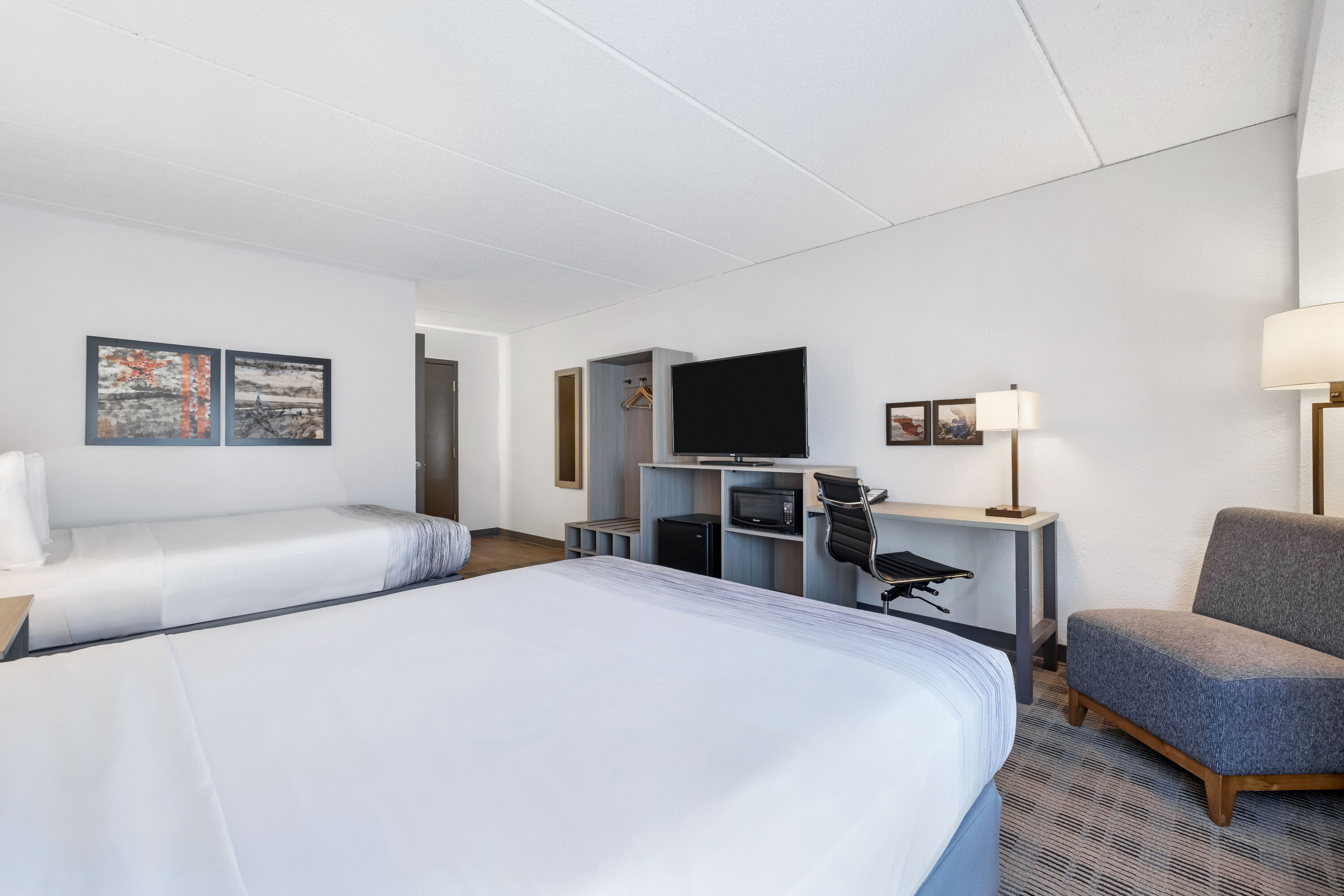 Queen bed guest room at the AmericInn by Wyndham Baxter Brainerd in Baxter, Minnesota