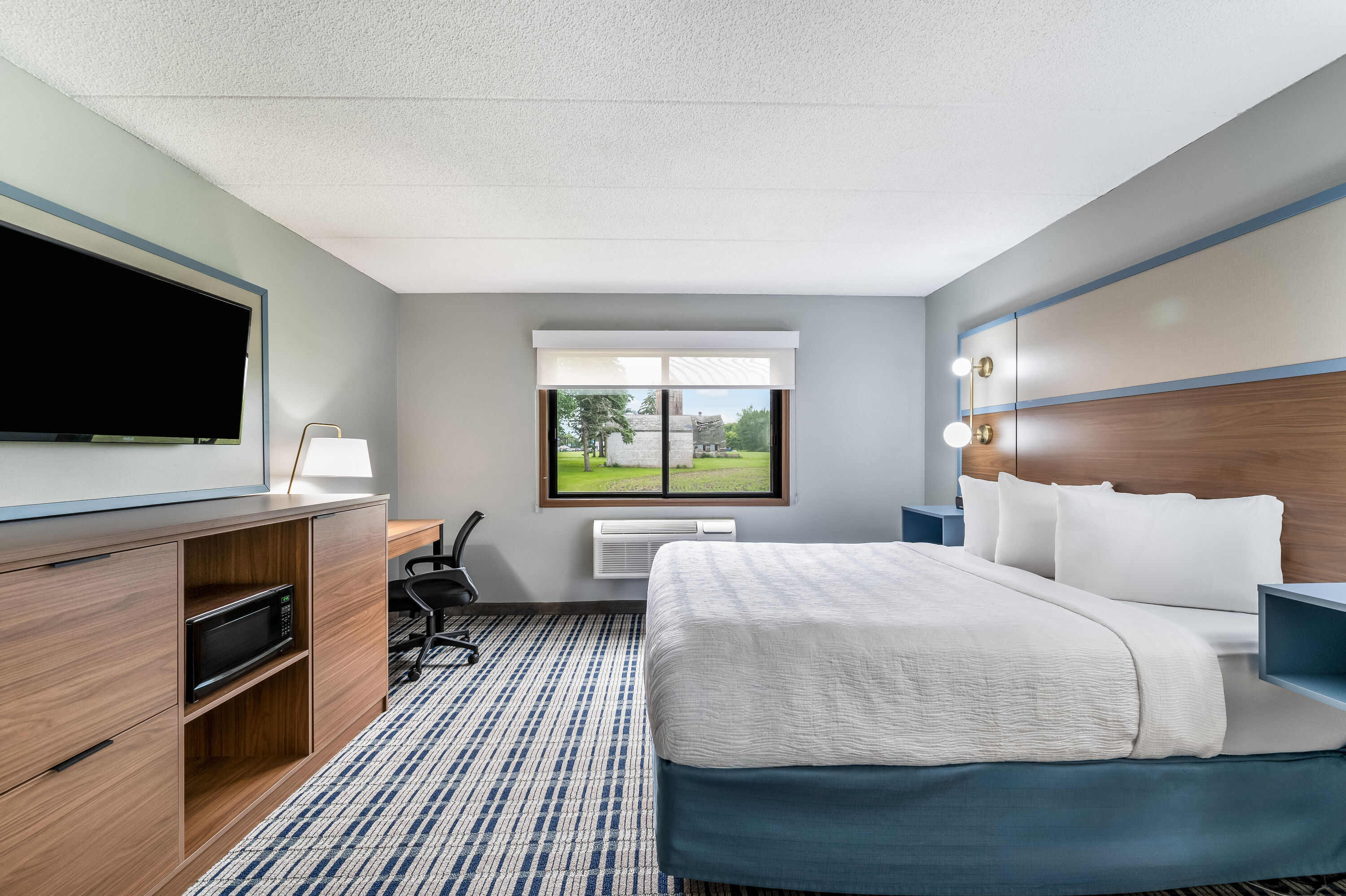 Queen bed guest room at the AmericInn by Wyndham Hutchinson in Hutchinson, Minnesota
