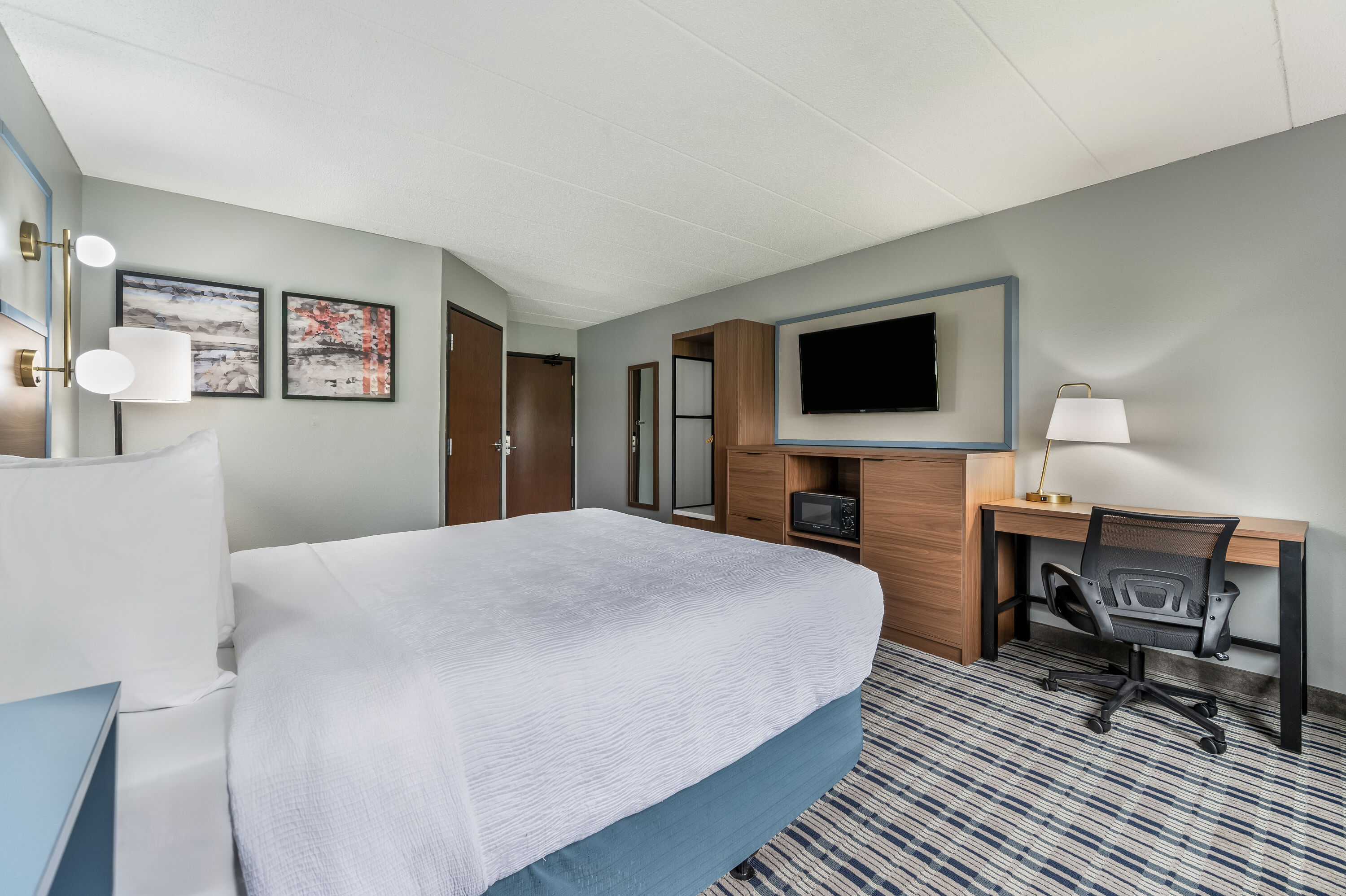Queen bed guest room at the AmericInn by Wyndham Hutchinson in Hutchinson, Minnesota
