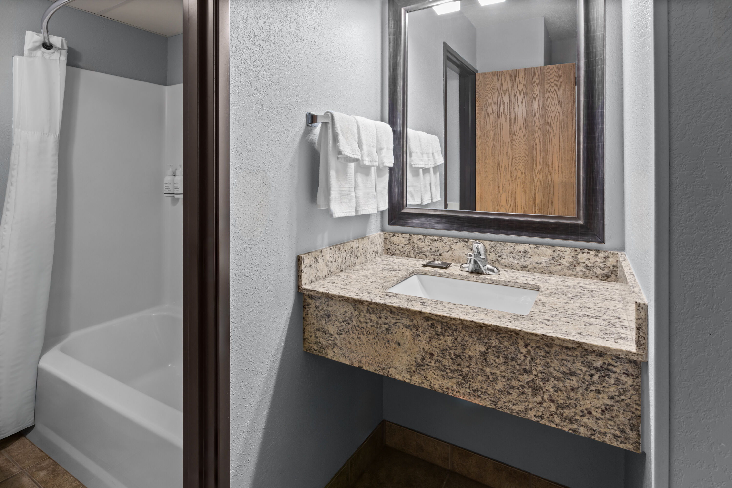 Guest room bath at the AmericInn by Wyndham Mankato Event Center in Mankato, Minnesota