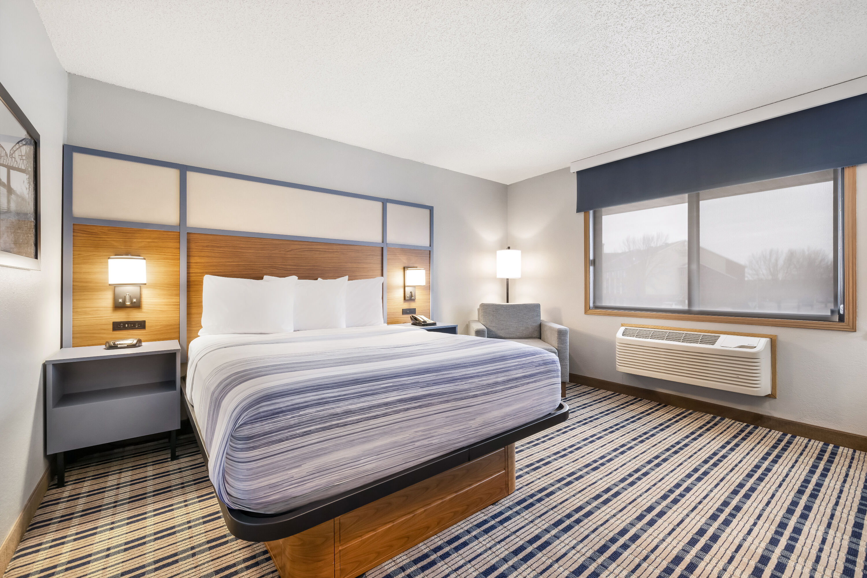 Queen bed guest room at the AmericInn by Wyndham Bismarck in Bismarck, North Dakota