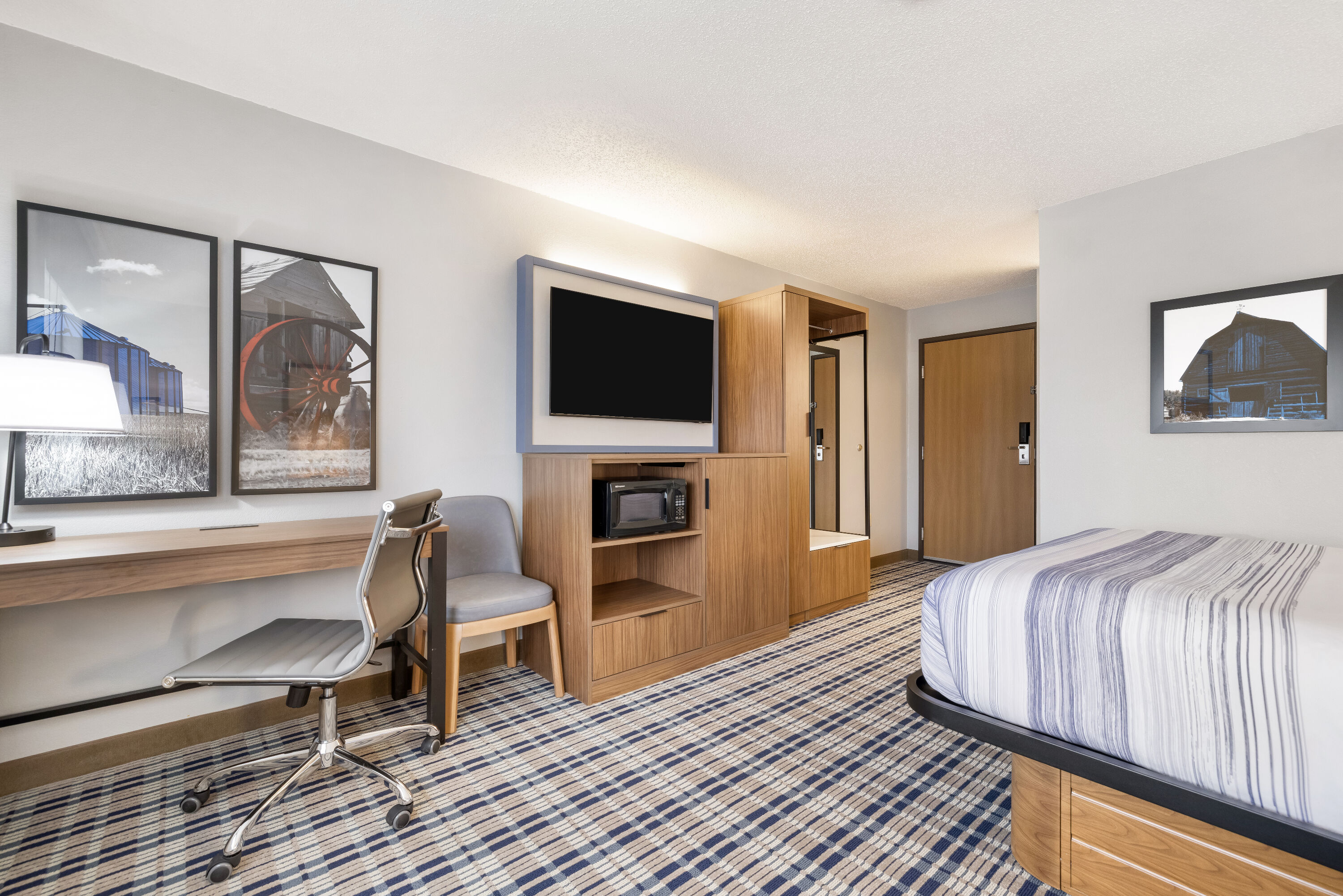Queen bed guest room at the AmericInn by Wyndham Bismarck in Bismarck, North Dakota