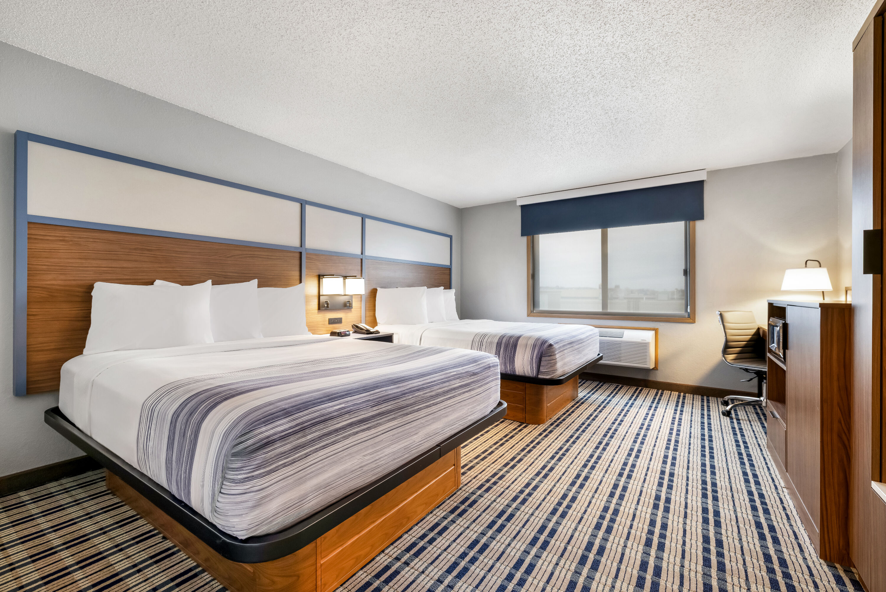 Queen bed guest room at the AmericInn by Wyndham Bismarck in Bismarck, North Dakota