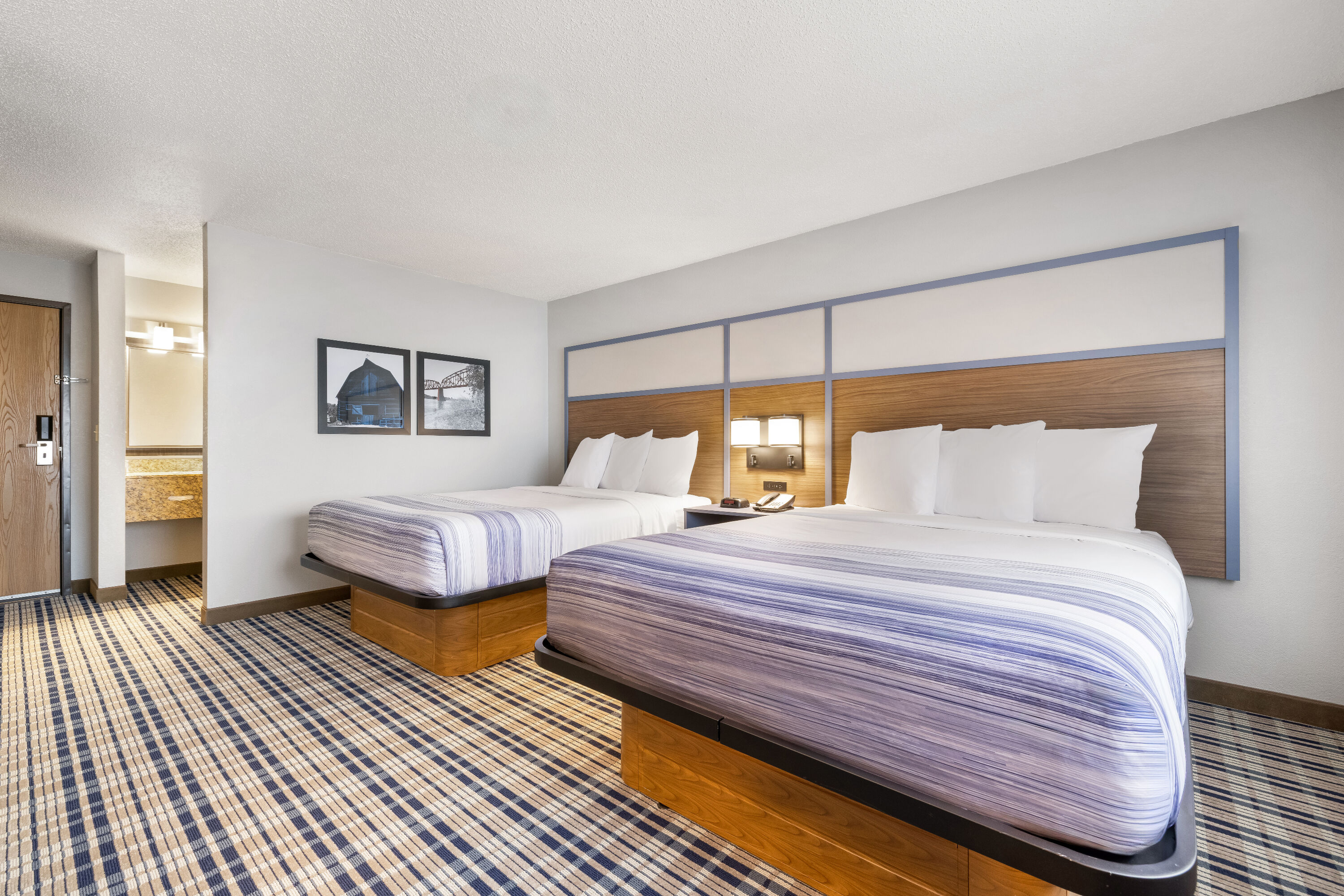 Queen bed guest room at the AmericInn by Wyndham Bismarck in Bismarck, North Dakota