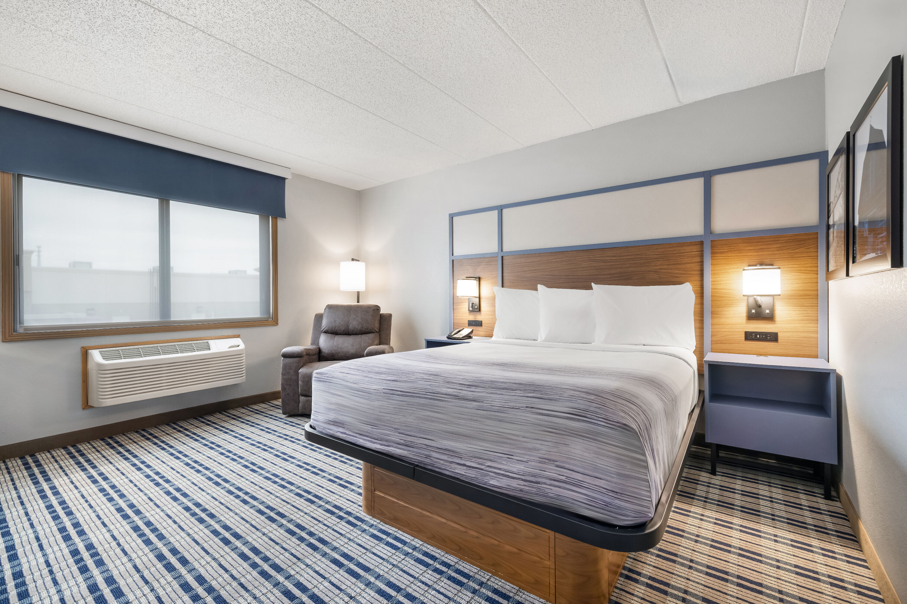 Queen bed guest room at the AmericInn by Wyndham Bismarck in Bismarck, North Dakota