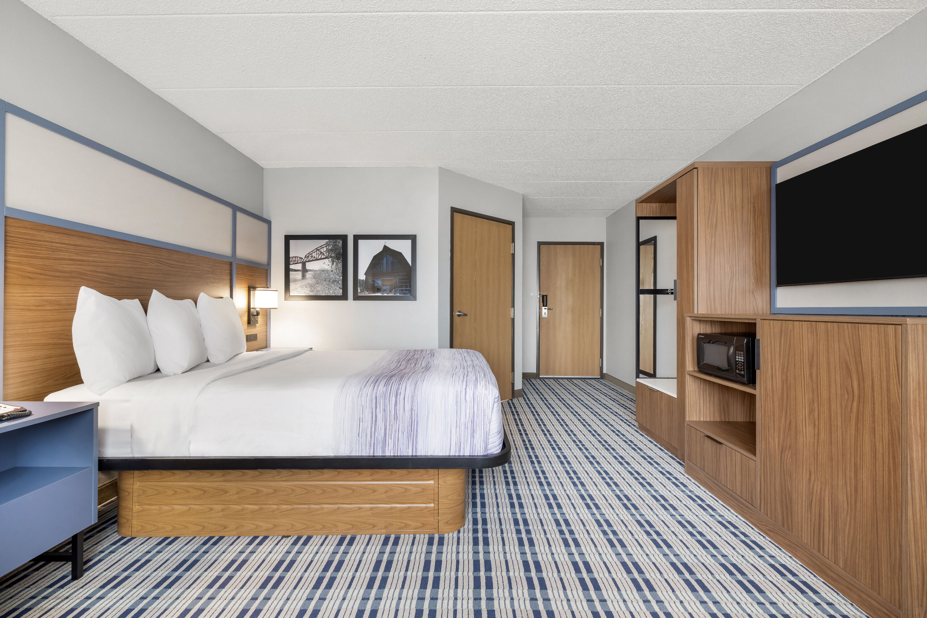 Queen bed guest room at the AmericInn by Wyndham Bismarck in Bismarck, North Dakota