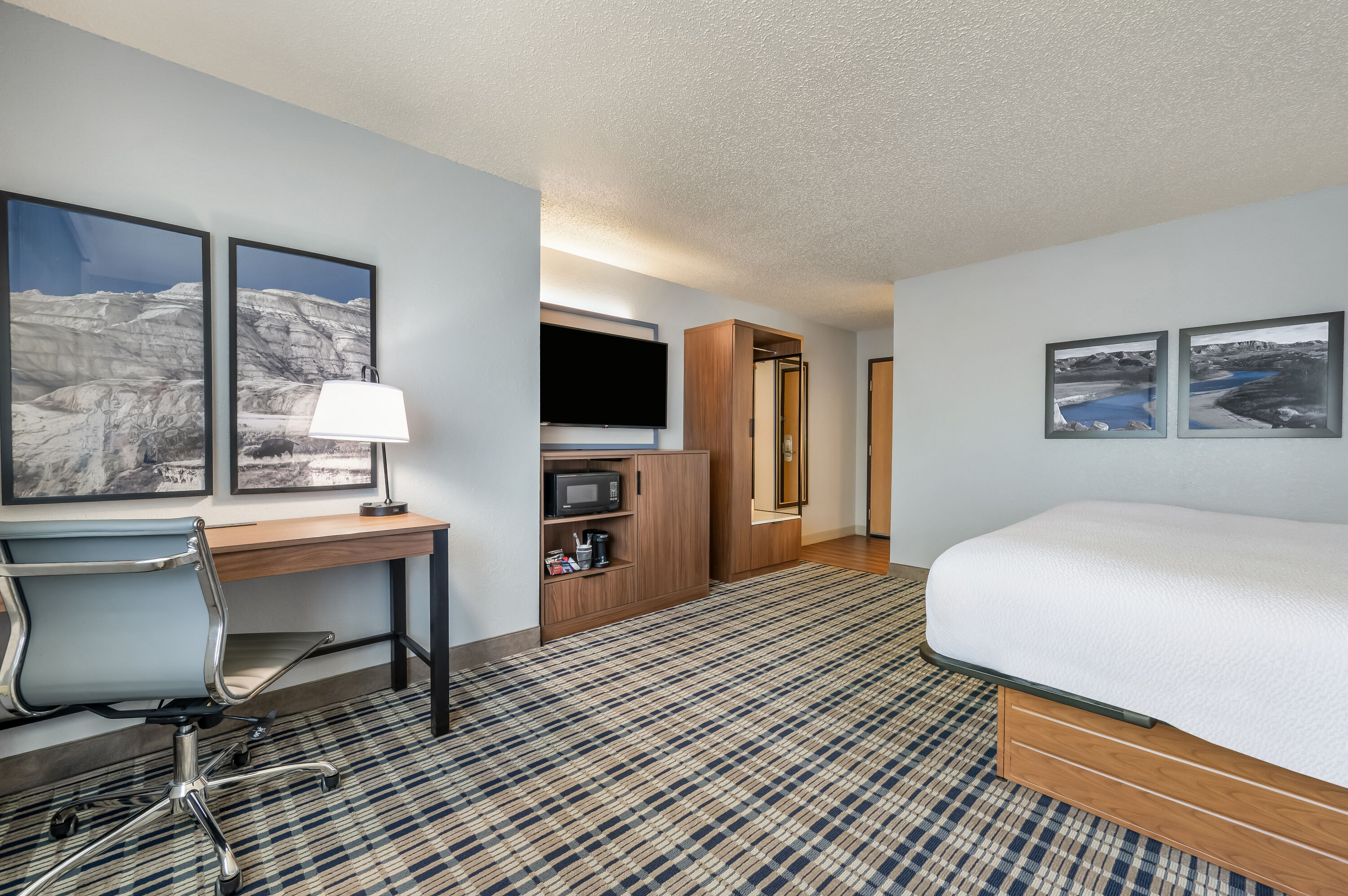 King bed guest room at the AmericInn by Wyndham Dickinson in Dickinson, North Dakota