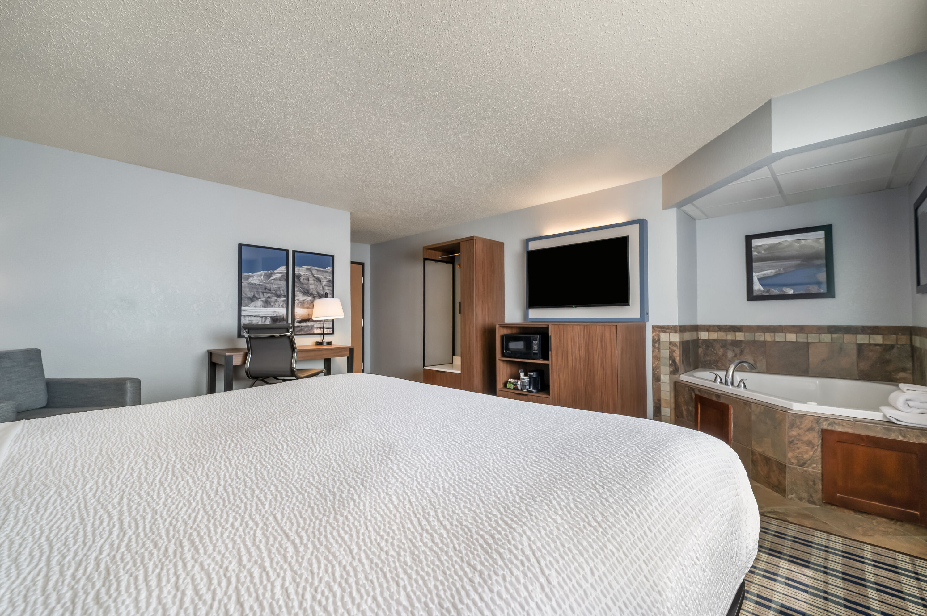King bed guest room at the AmericInn by Wyndham Dickinson in Dickinson, North Dakota