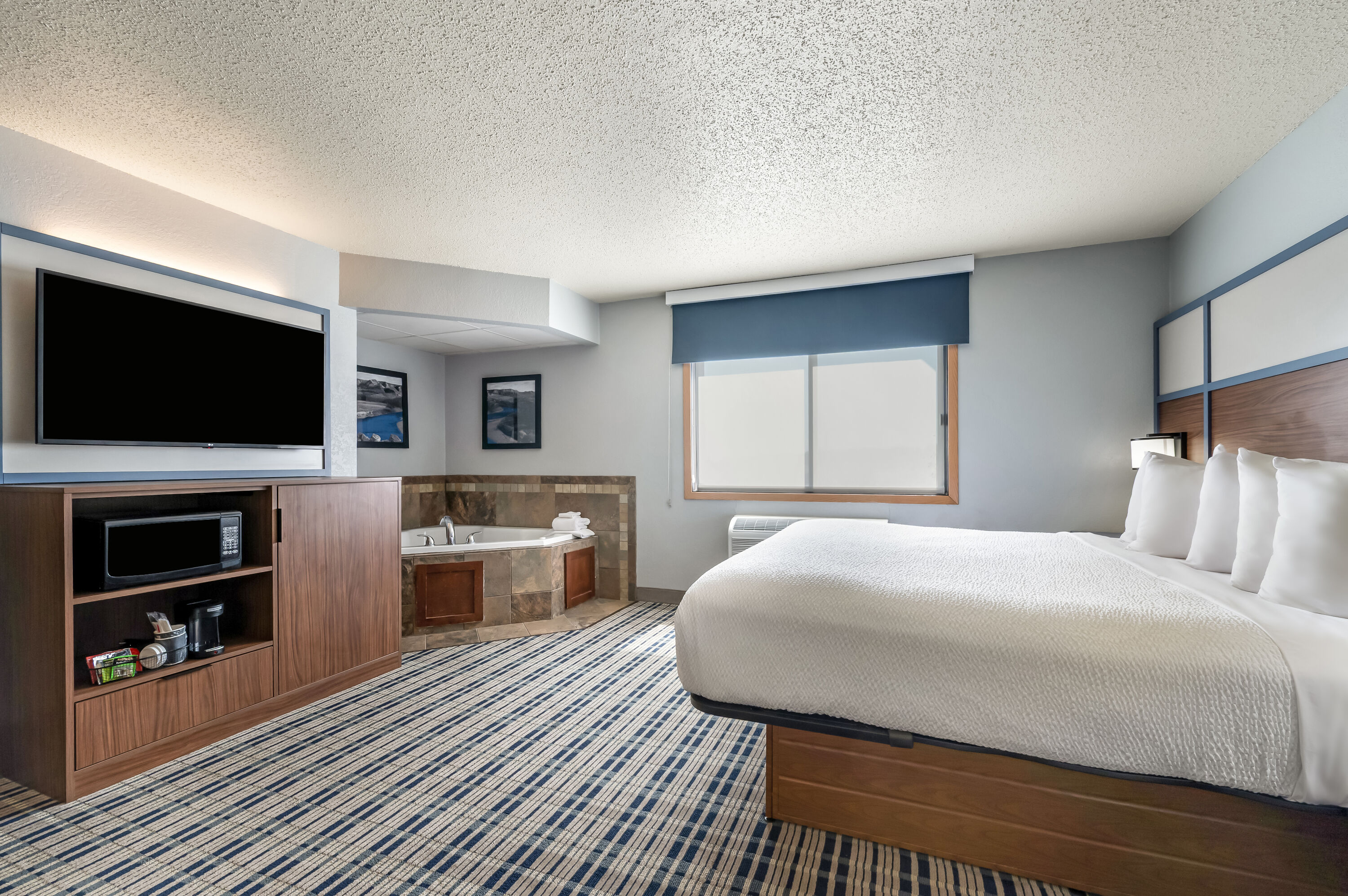 King bed guest room at the AmericInn by Wyndham Dickinson in Dickinson, North Dakota