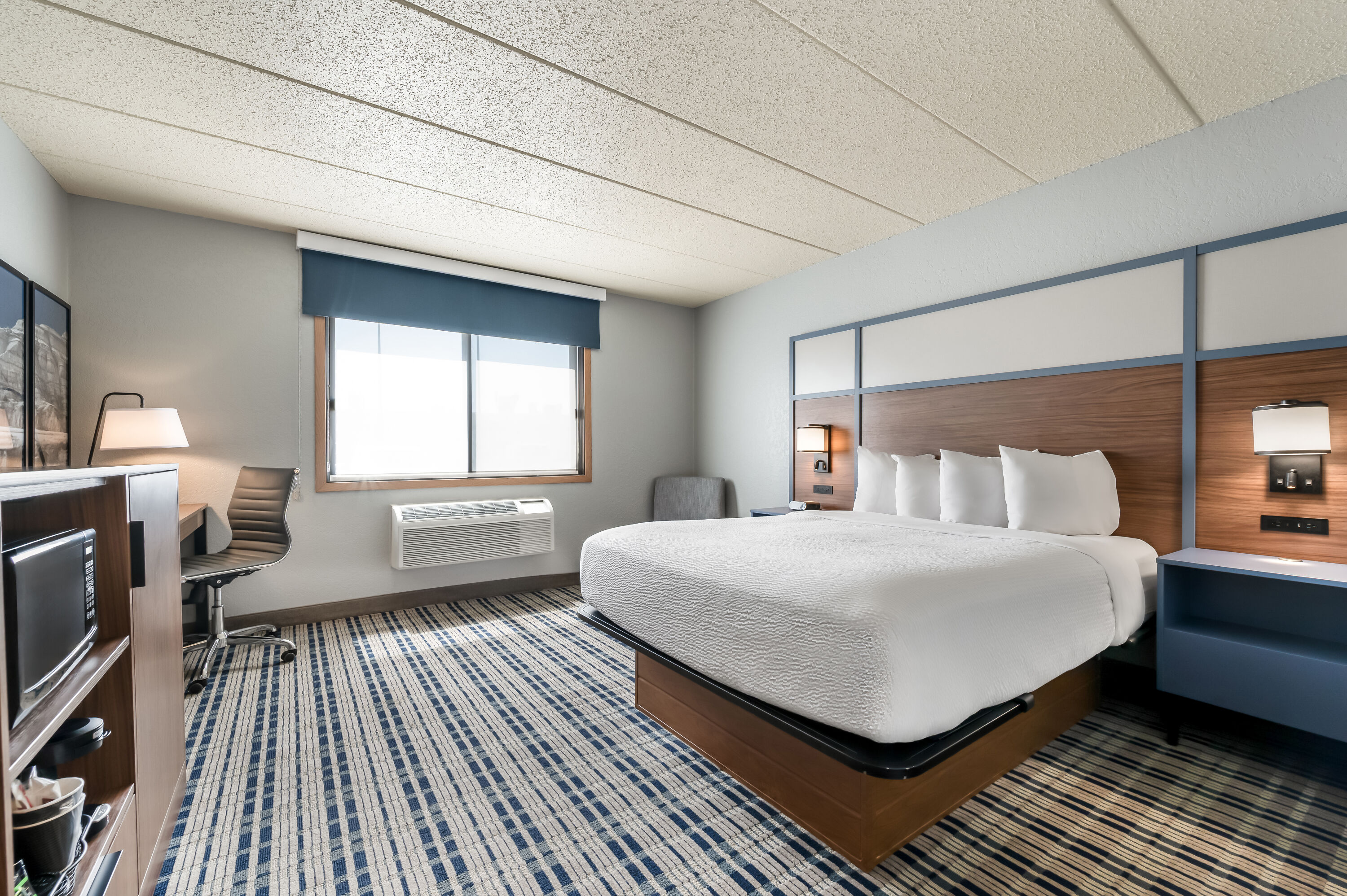 Queen bed guest room at the AmericInn by Wyndham Dickinson in Dickinson, North Dakota