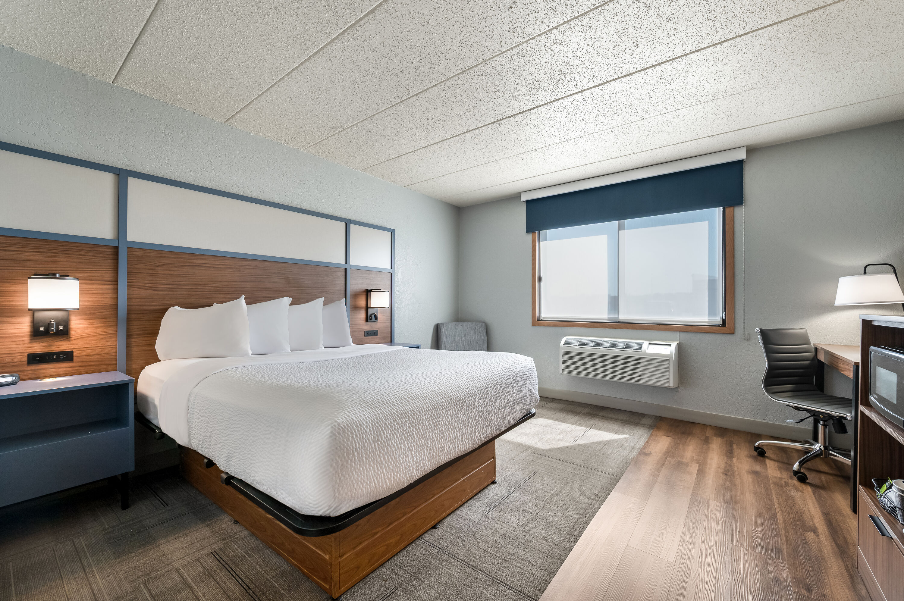 Queen bed guest room at the AmericInn by Wyndham Dickinson in Dickinson, North Dakota