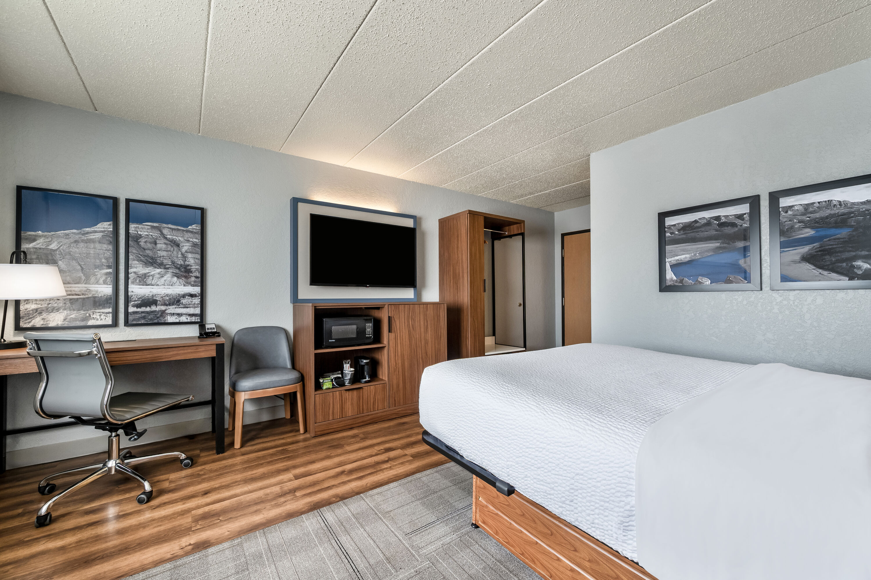 Queen bed guest room at the AmericInn by Wyndham Dickinson in Dickinson, North Dakota