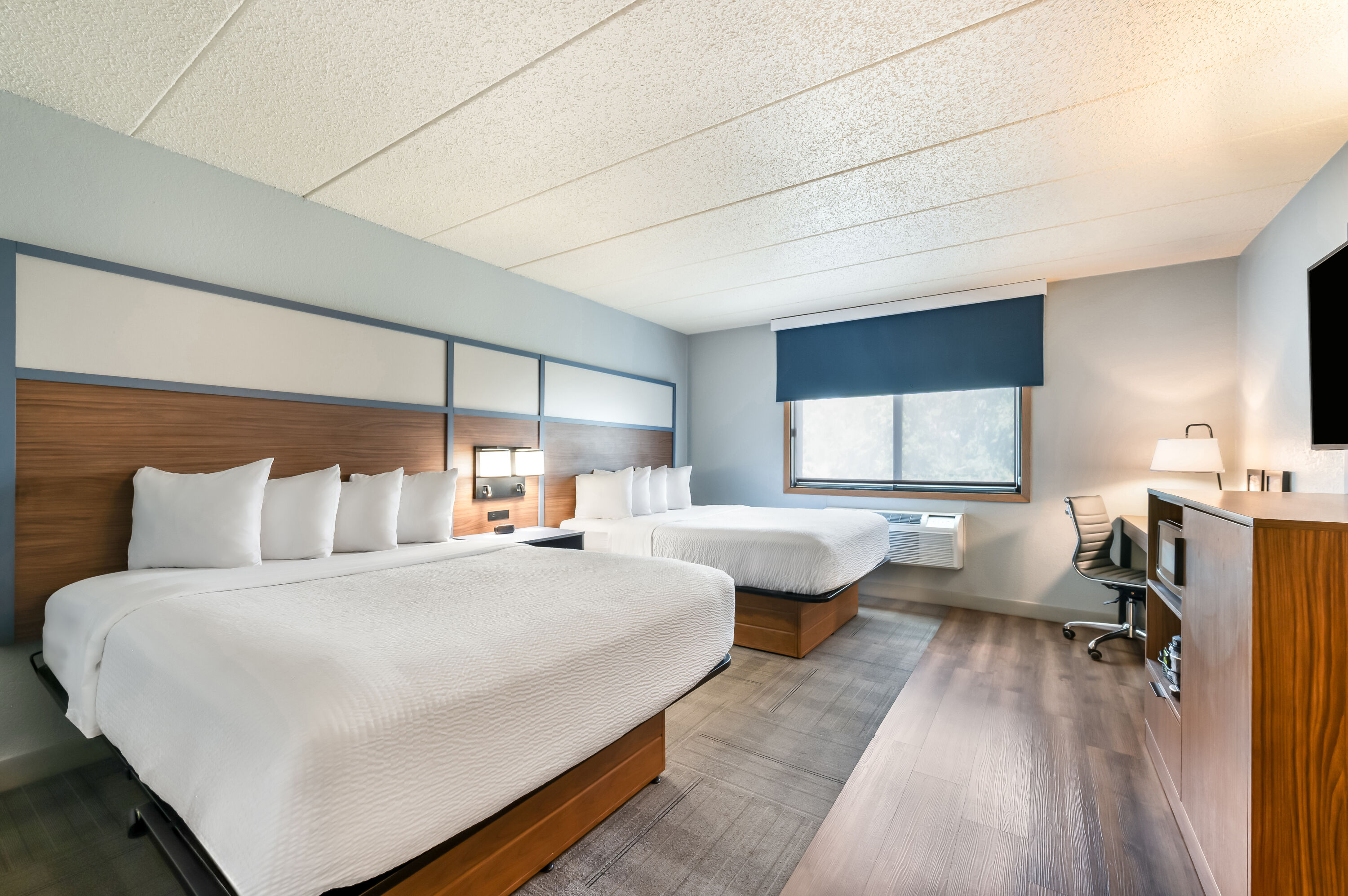 Queen bed guest room at the AmericInn by Wyndham Dickinson in Dickinson, North Dakota