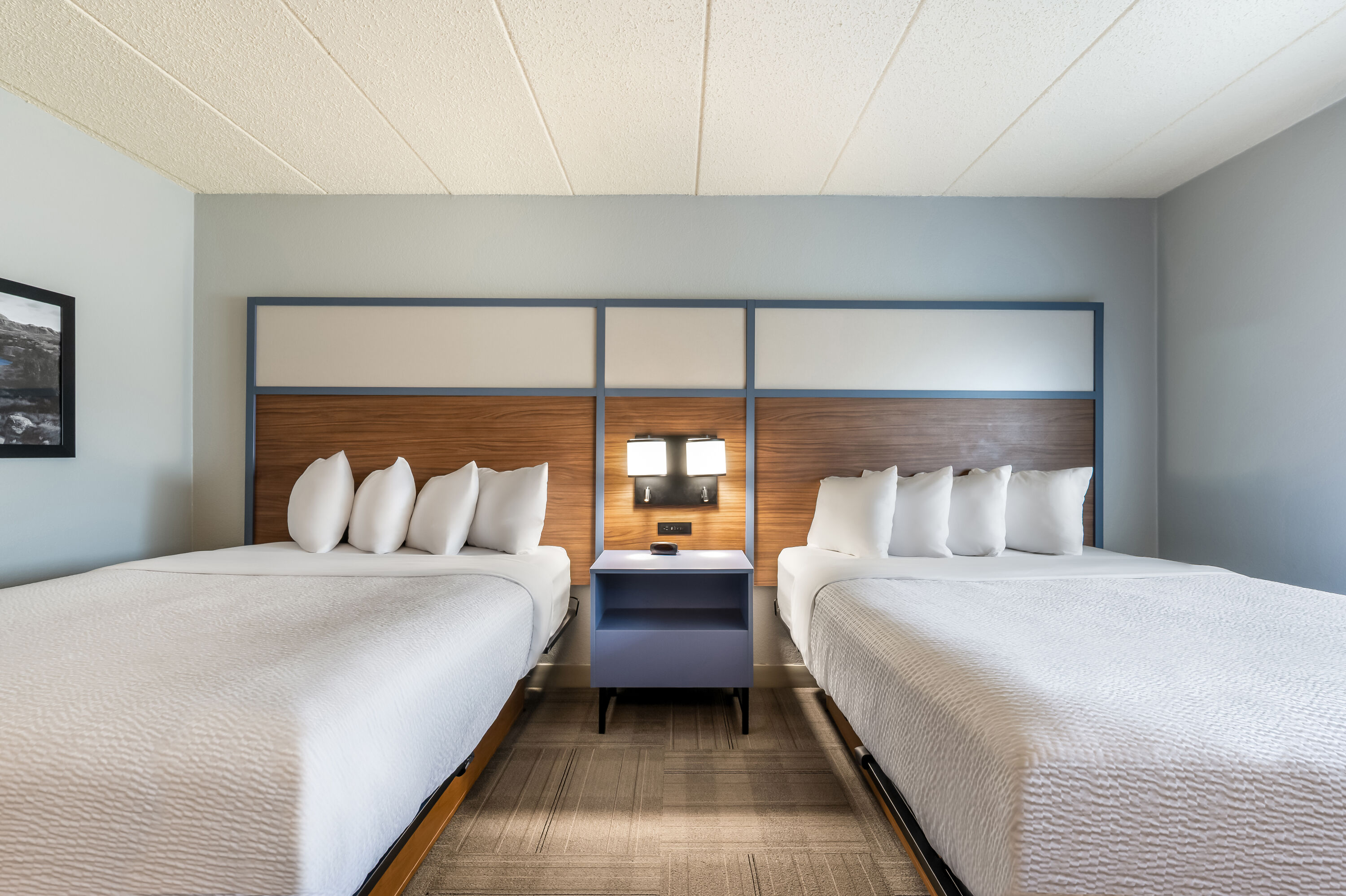 Queen bed guest room at the AmericInn by Wyndham Dickinson in Dickinson, North Dakota