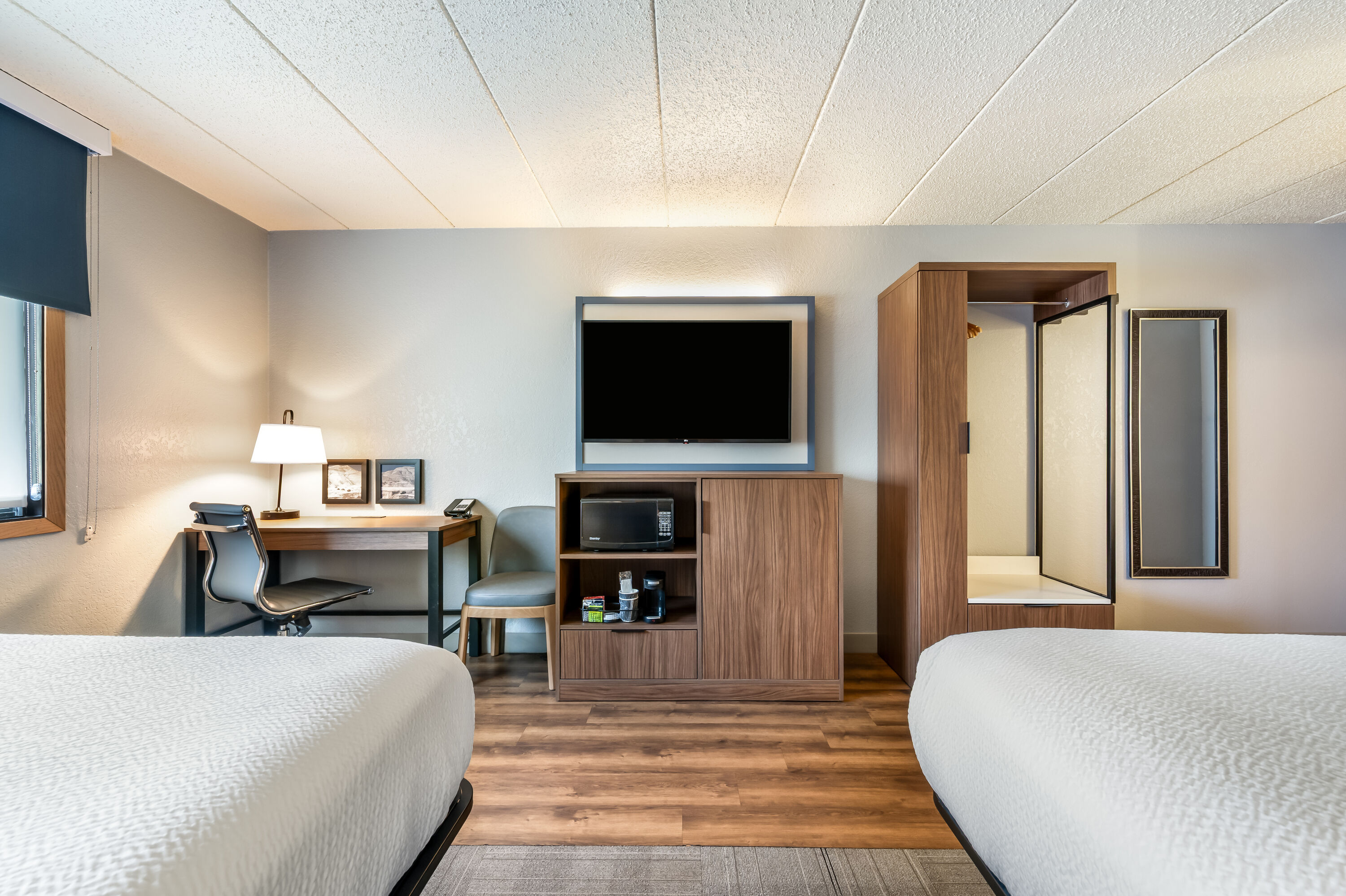 Queen bed guest room at the AmericInn by Wyndham Dickinson in Dickinson, North Dakota