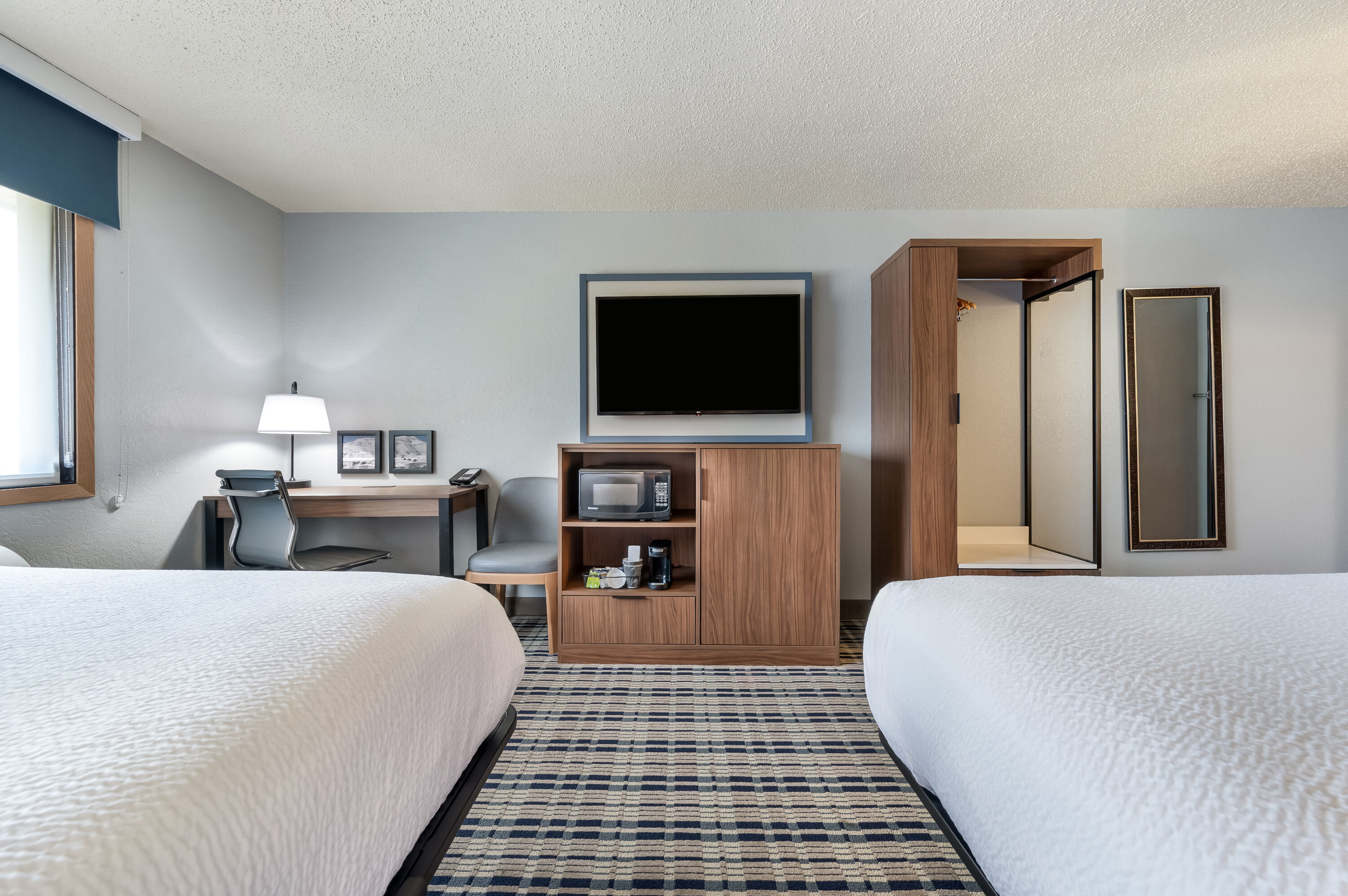 Queen bed guest room at the AmericInn by Wyndham Dickinson in Dickinson, North Dakota