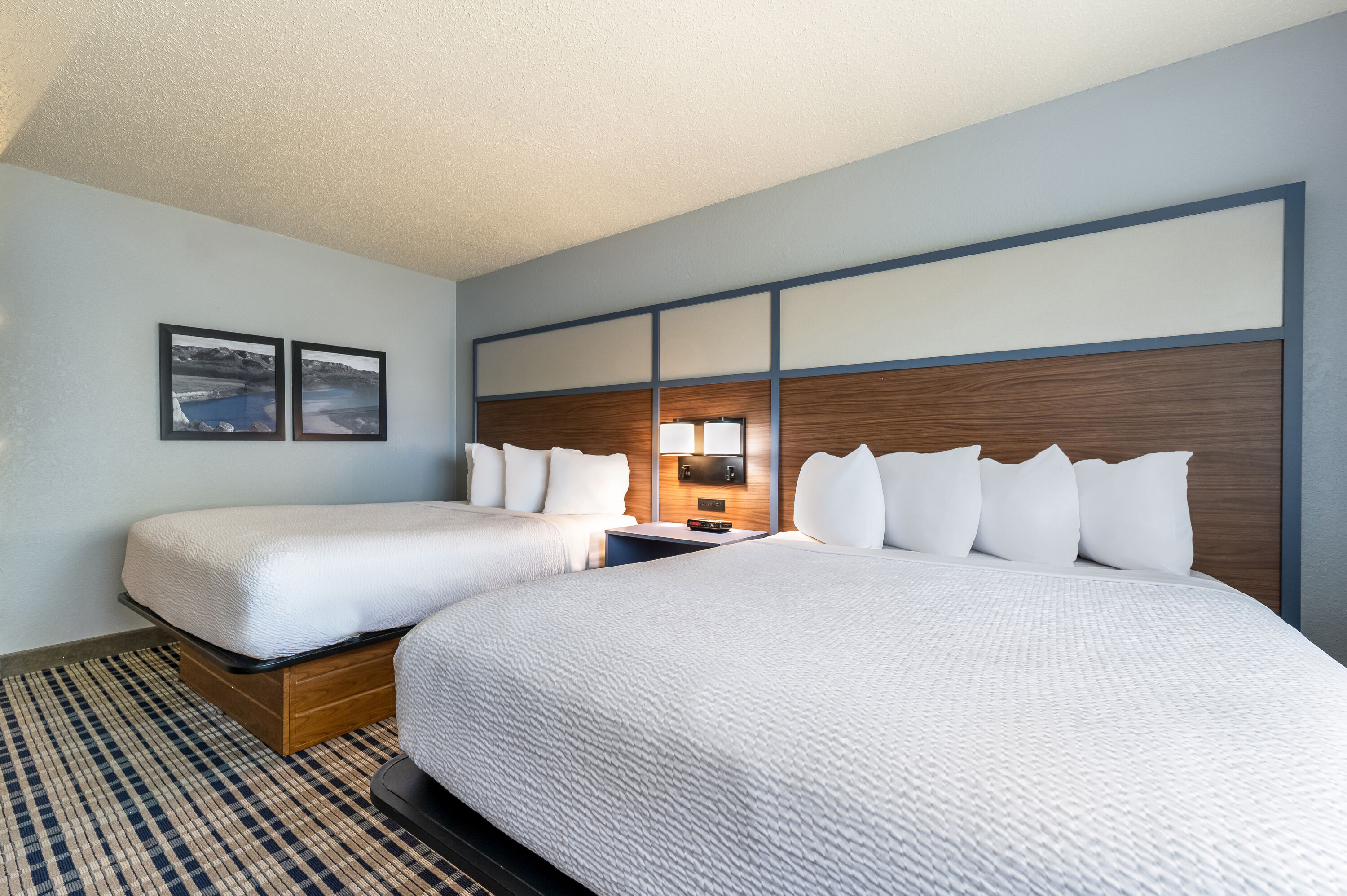 Queen bed guest room at the AmericInn by Wyndham Dickinson in Dickinson, North Dakota