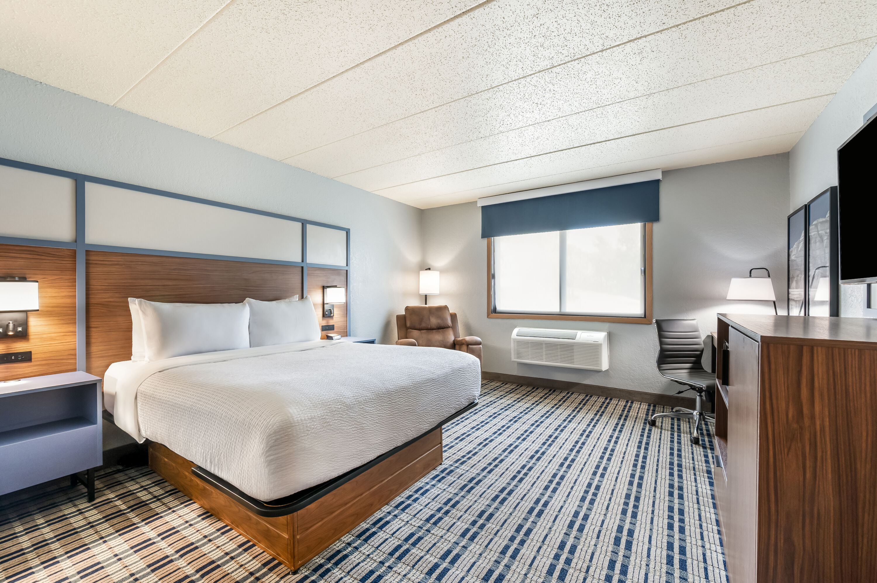 Queen bed guest room at the AmericInn by Wyndham Dickinson in Dickinson, North Dakota