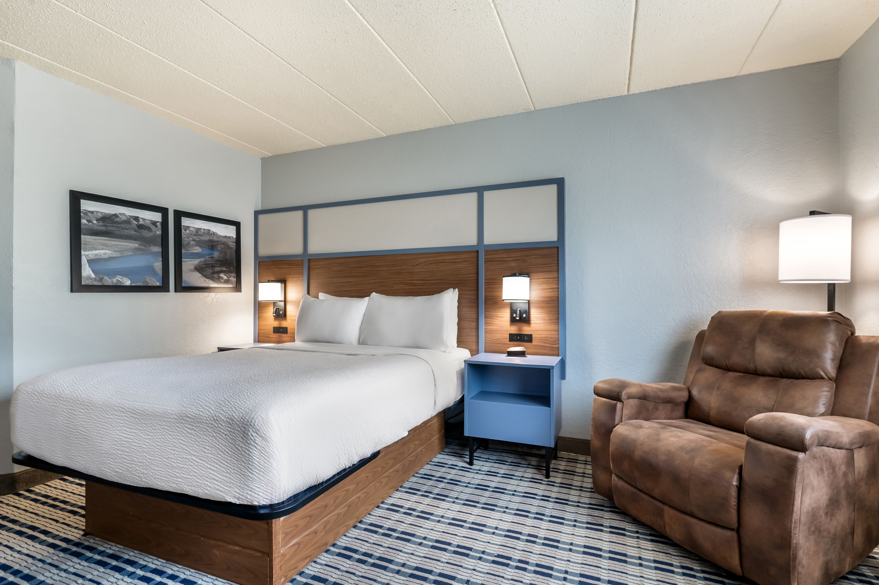 Queen bed guest room at the AmericInn by Wyndham Dickinson in Dickinson, North Dakota