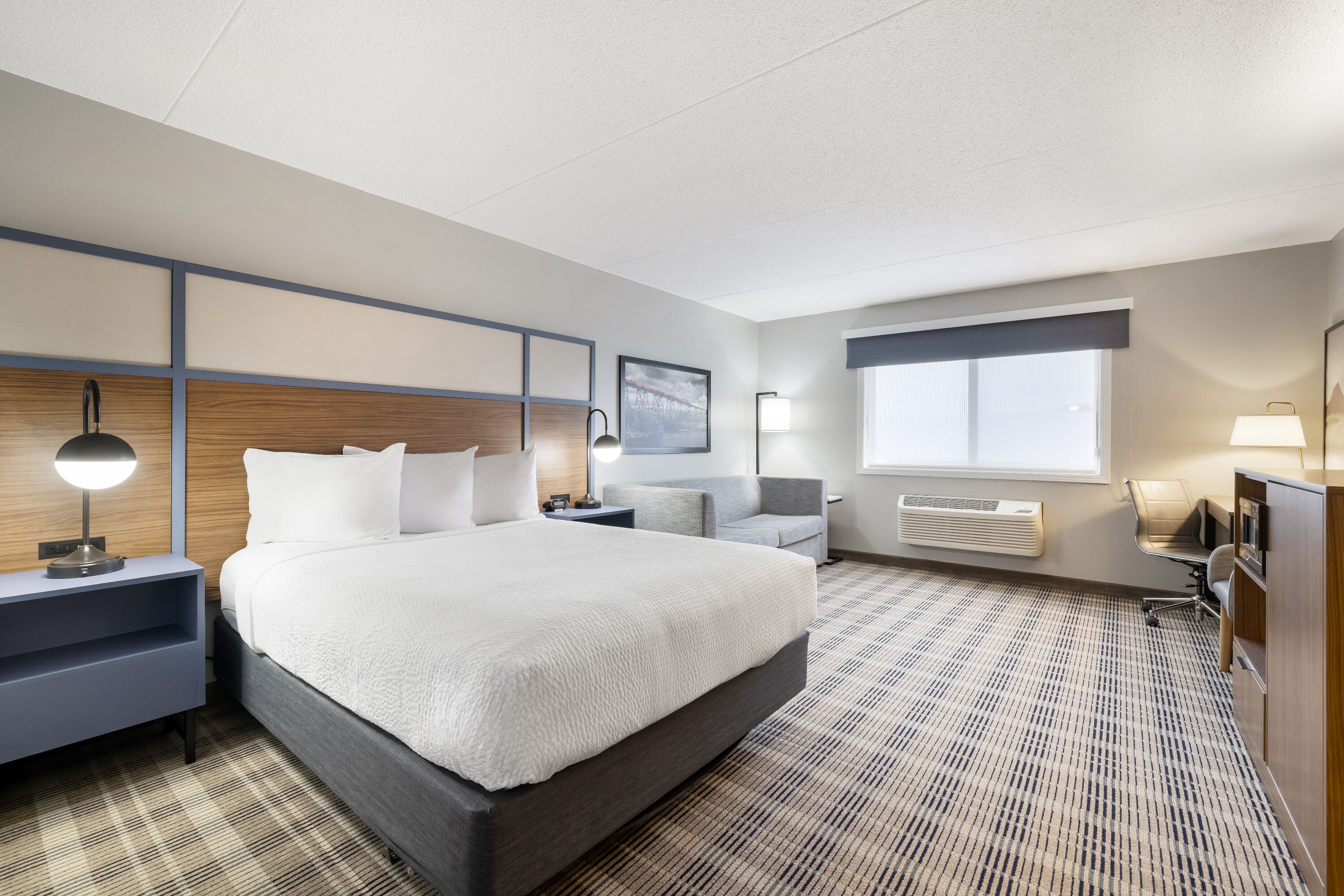 Queen bed guest room at the AmericInn by Wyndham Valley City Conference Center in Valley City, North Dakota