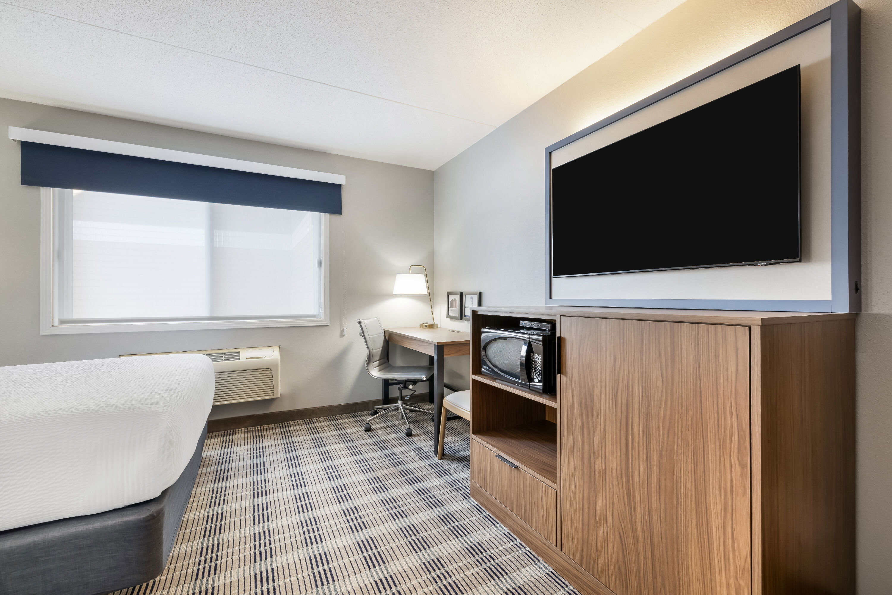 Queen bed guest room at the AmericInn by Wyndham Valley City Conference Center in Valley City, North Dakota