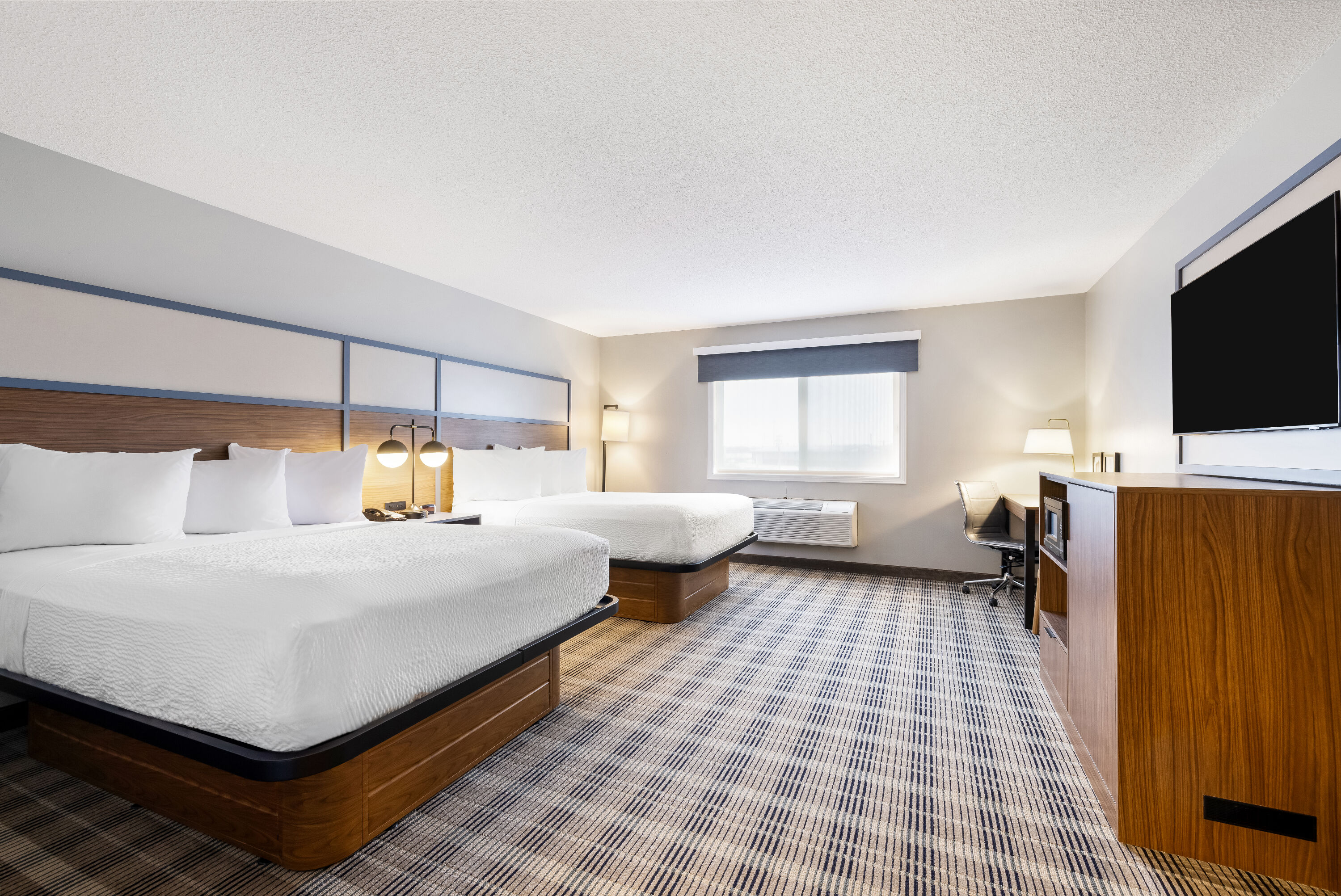 Queen bed guest room at the AmericInn by Wyndham Valley City Conference Center in Valley City, North Dakota