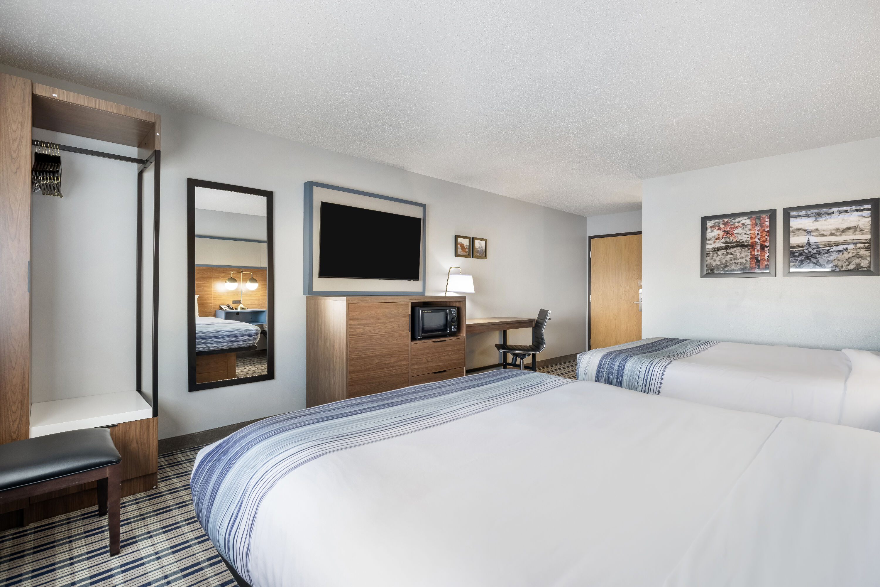 Queen bed guest room at the AmericInn by Wyndham Aberdeen Event Center in Aberdeen, South Dakota