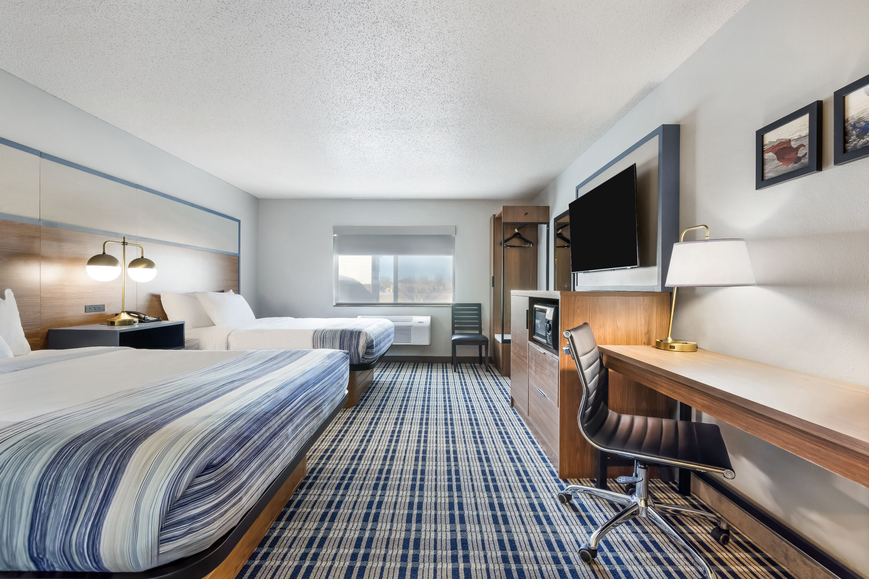 Queen bed guest room at the AmericInn by Wyndham Aberdeen Event Center in Aberdeen, South Dakota