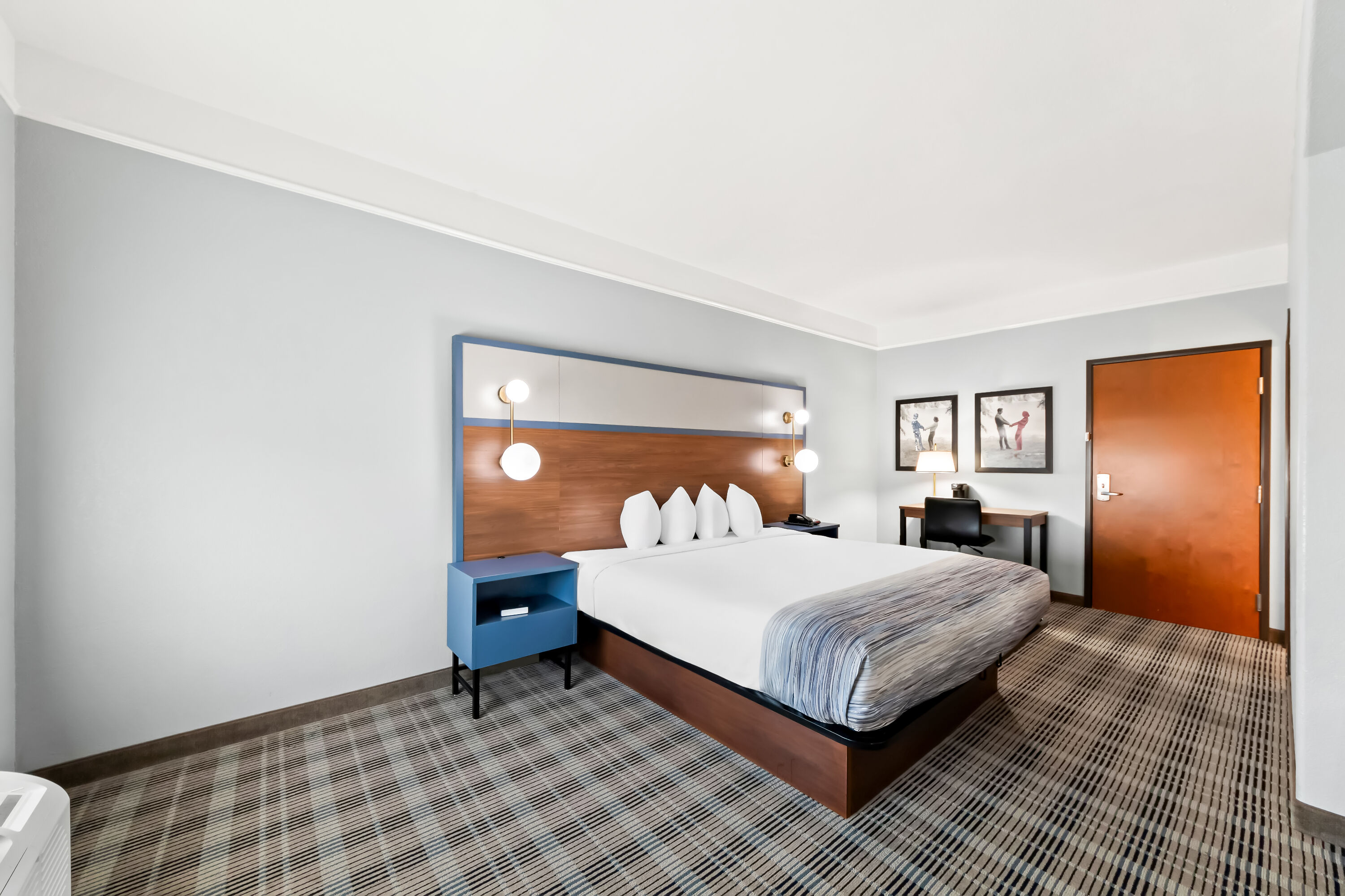 Queen bed guest room at the AmericInn by Wyndham New Braunfels in New Braunfels, Texas