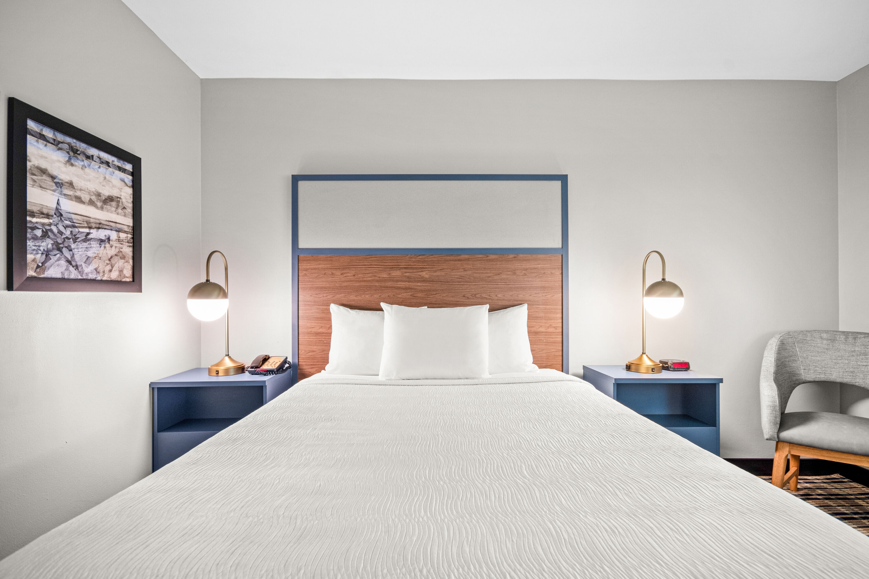 Queen bed guest room at the AmericInn by Wyndham Beloit in Beloit, Wisconsin