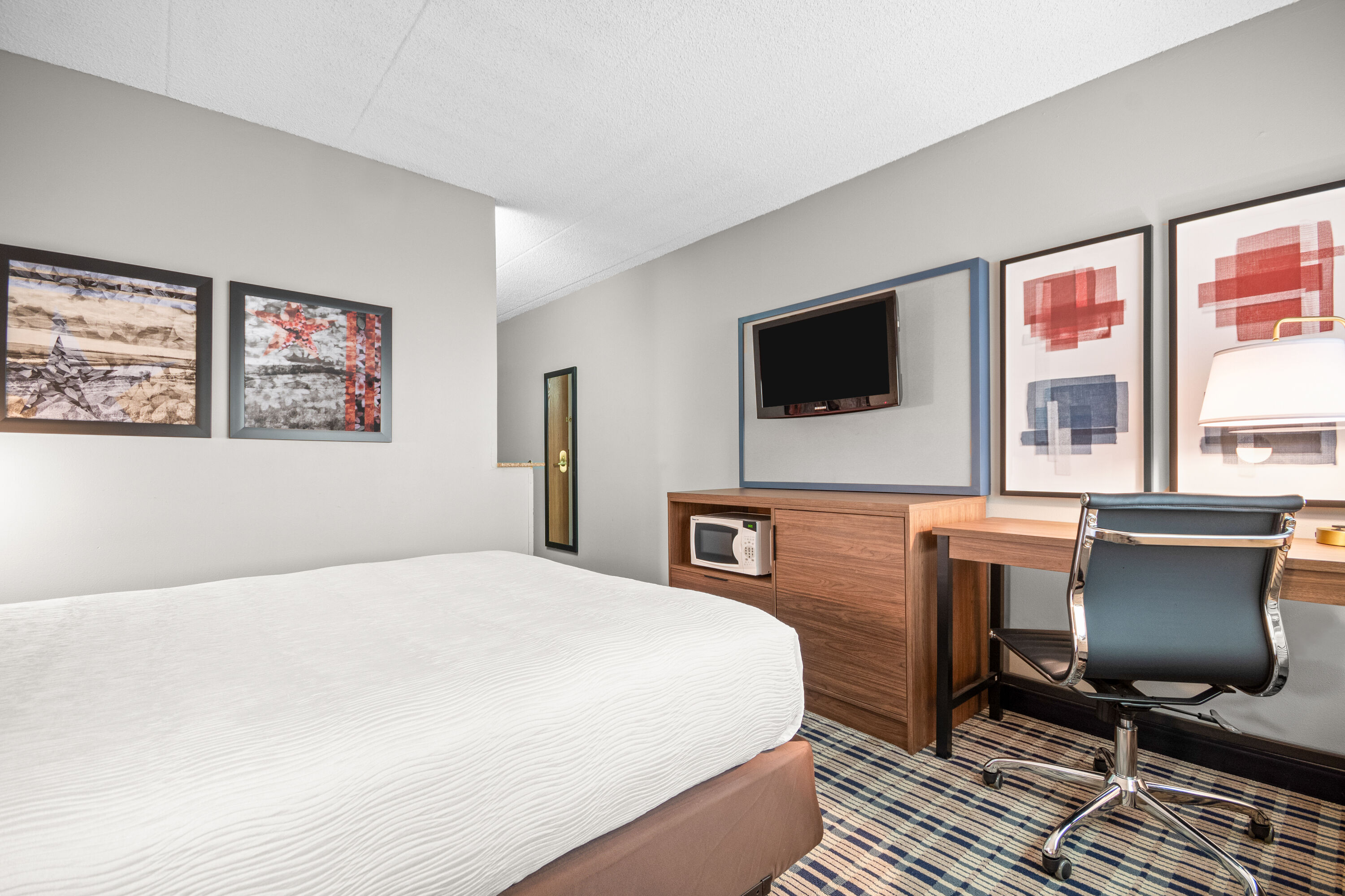 Queen bed guest room at the AmericInn by Wyndham Beloit in Beloit, Wisconsin