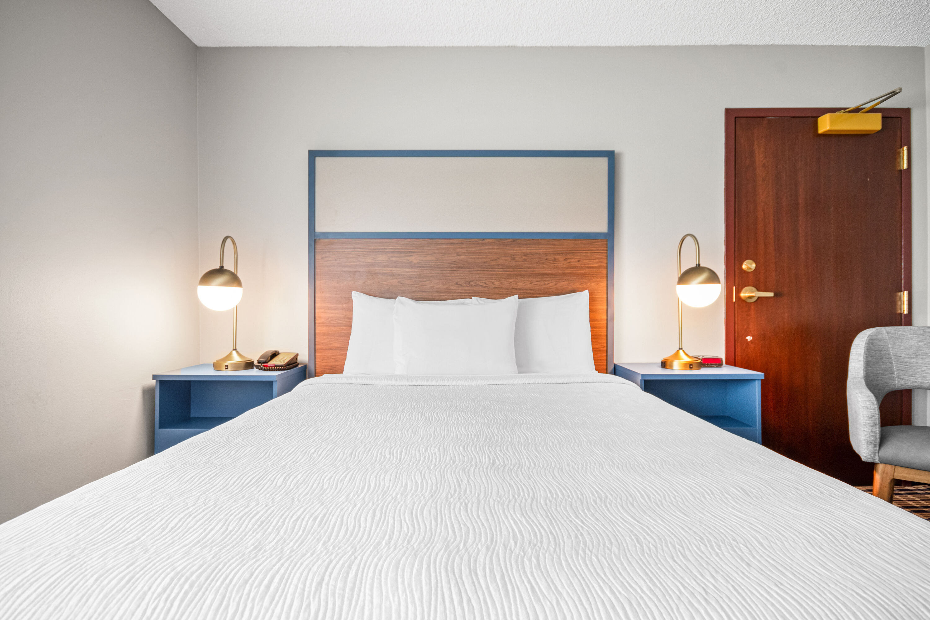 Queen bed guest room at the AmericInn by Wyndham Beloit in Beloit, Wisconsin