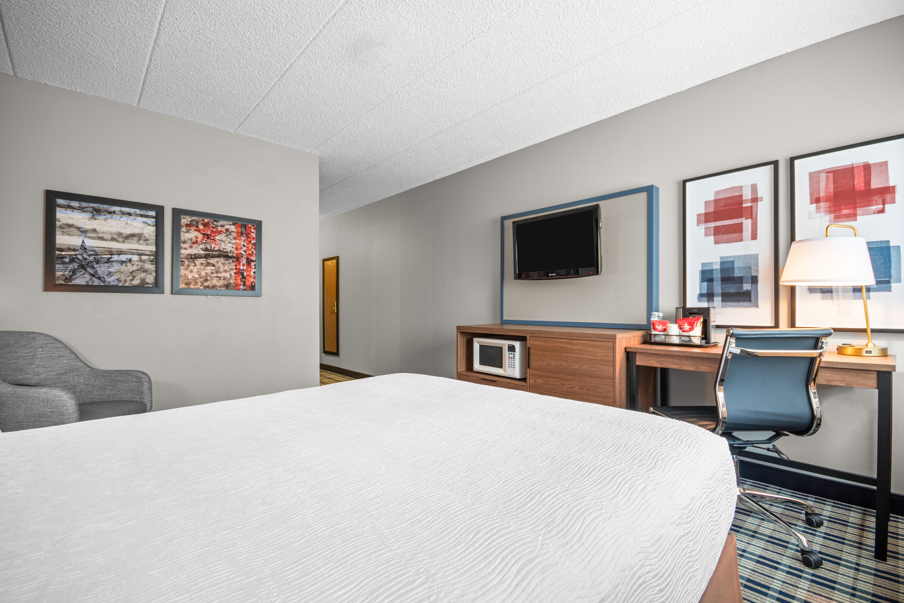 Queen bed guest room at the AmericInn by Wyndham Beloit in Beloit, Wisconsin