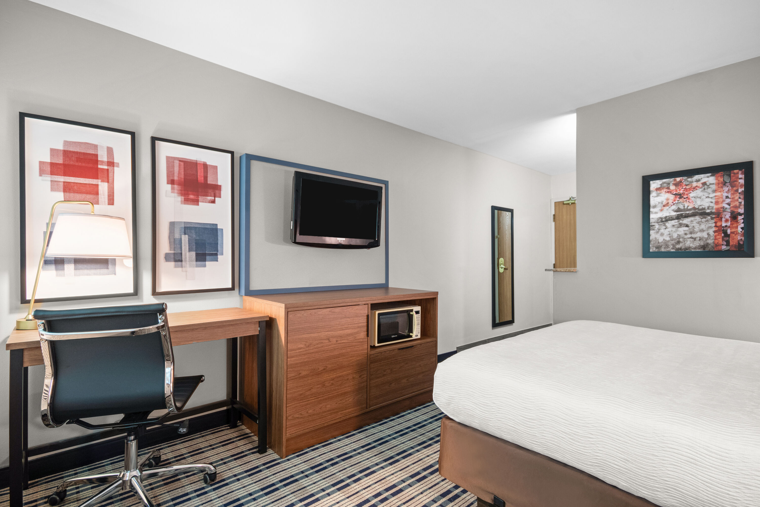 Queen bed guest room at the AmericInn by Wyndham Beloit in Beloit, Wisconsin