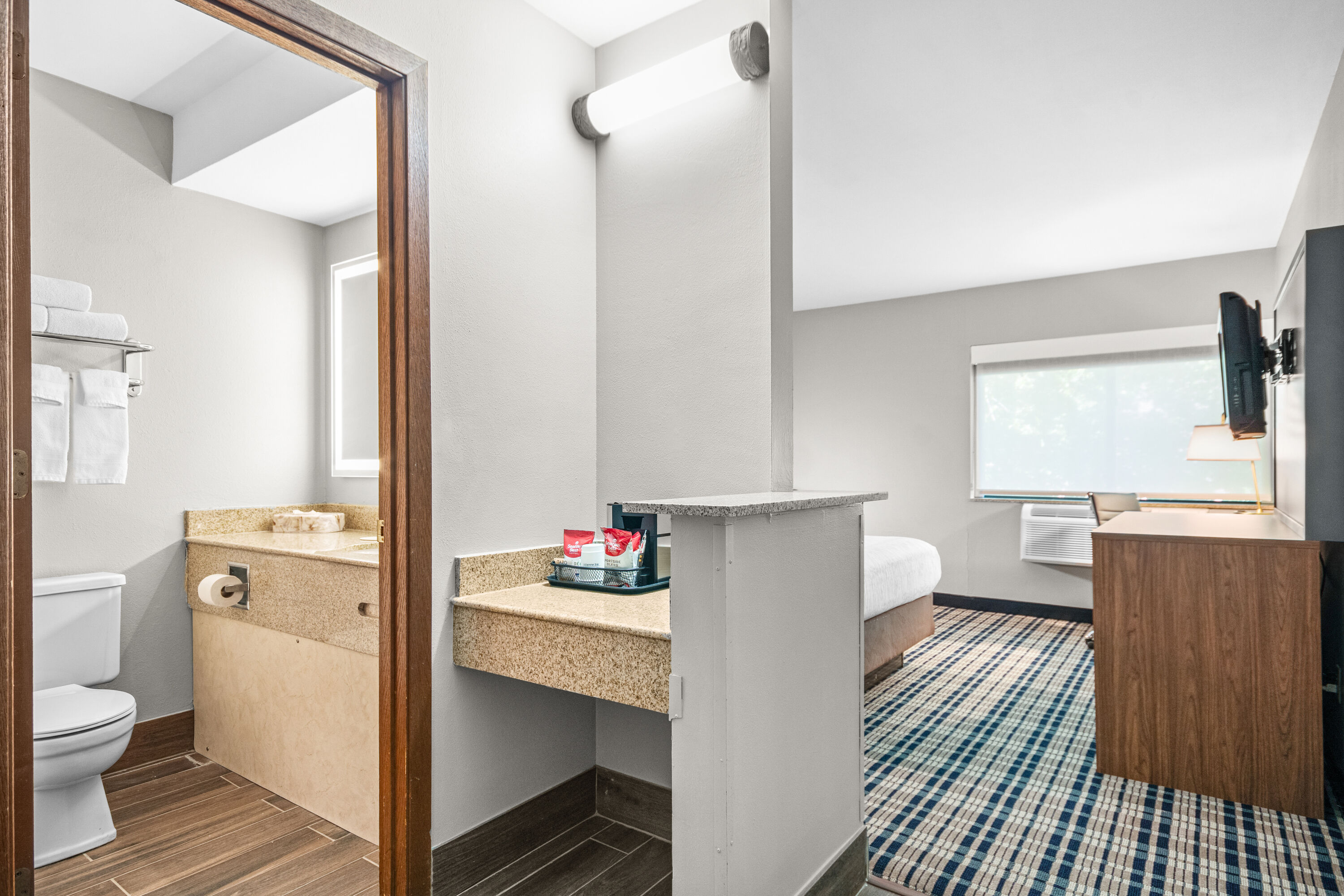 Queen bed guest room at the AmericInn by Wyndham Beloit in Beloit, Wisconsin