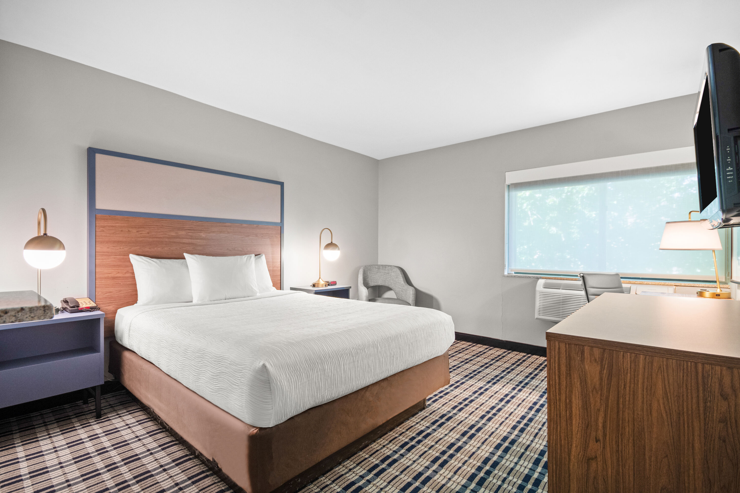 Queen bed guest room at the AmericInn by Wyndham Beloit in Beloit, Wisconsin