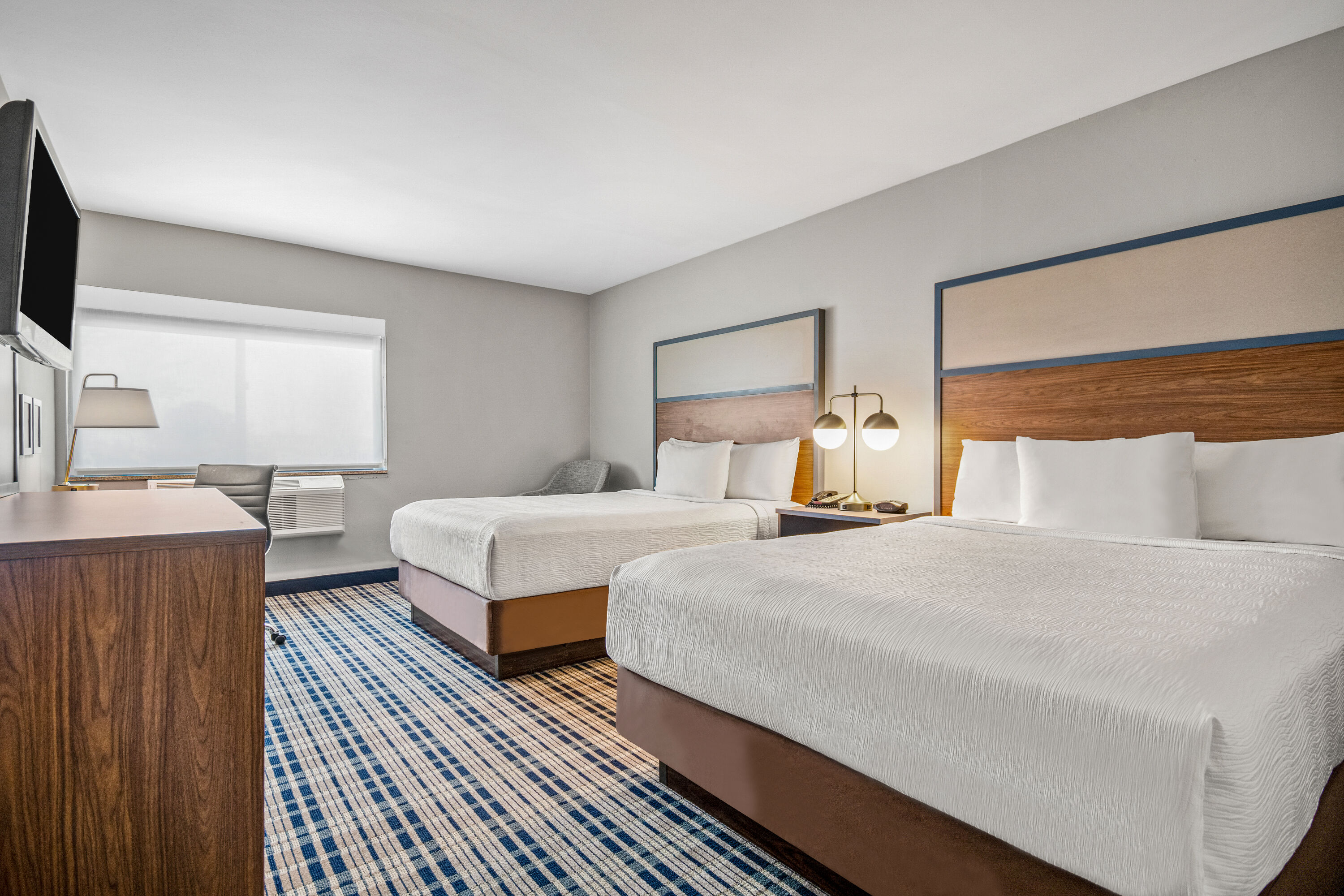 Queen bed guest room at the AmericInn by Wyndham Beloit in Beloit, Wisconsin