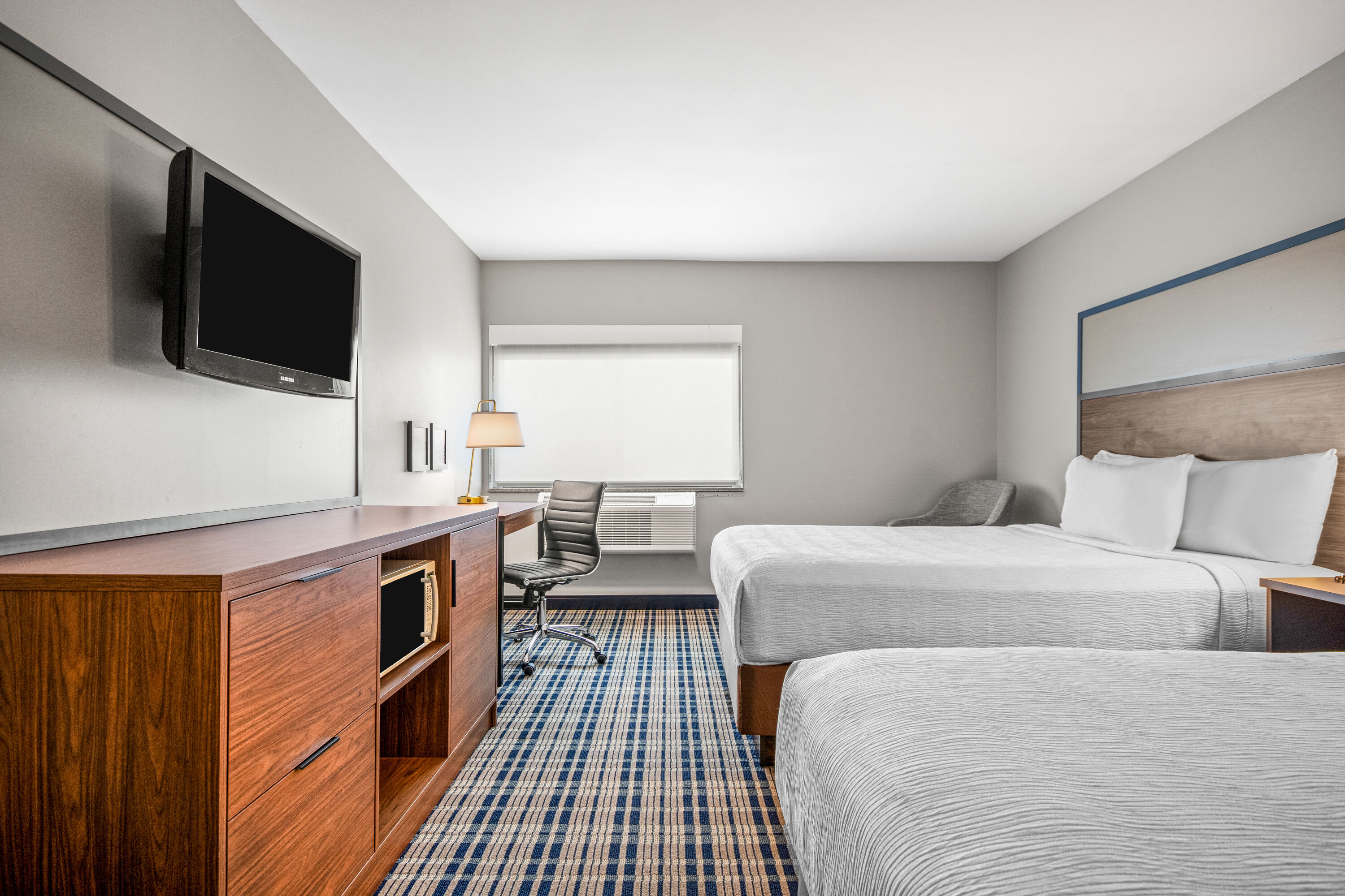 Queen bed guest room at the AmericInn by Wyndham Beloit in Beloit, Wisconsin